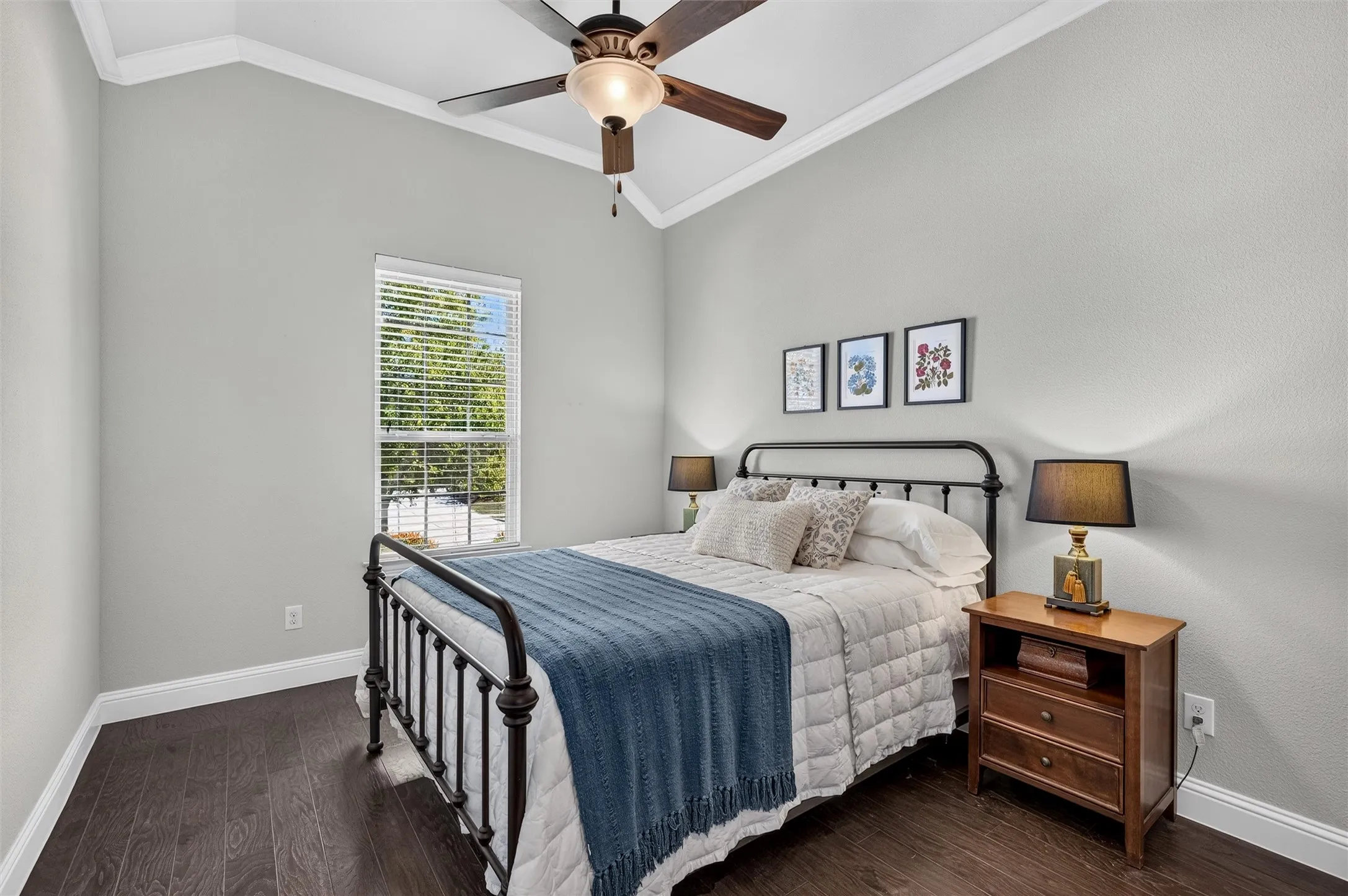 Vaulted ceiling with crown molding, ceiling fan, wood-finish flooring, and a single window with blinds