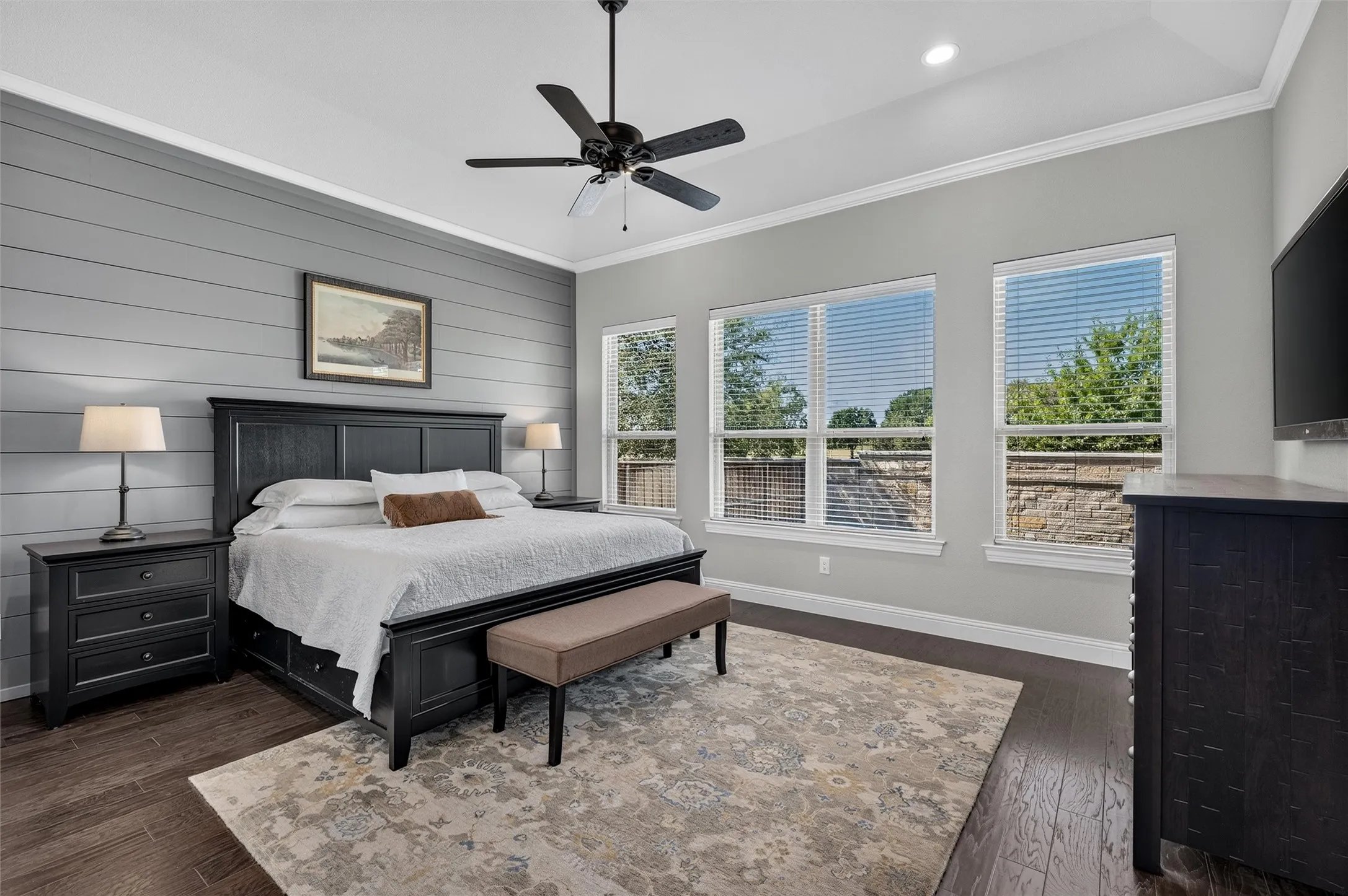 Accent wall with horizontal paneling, wood-finish flooring, ceiling fan, recessed lighting, and multiple windows