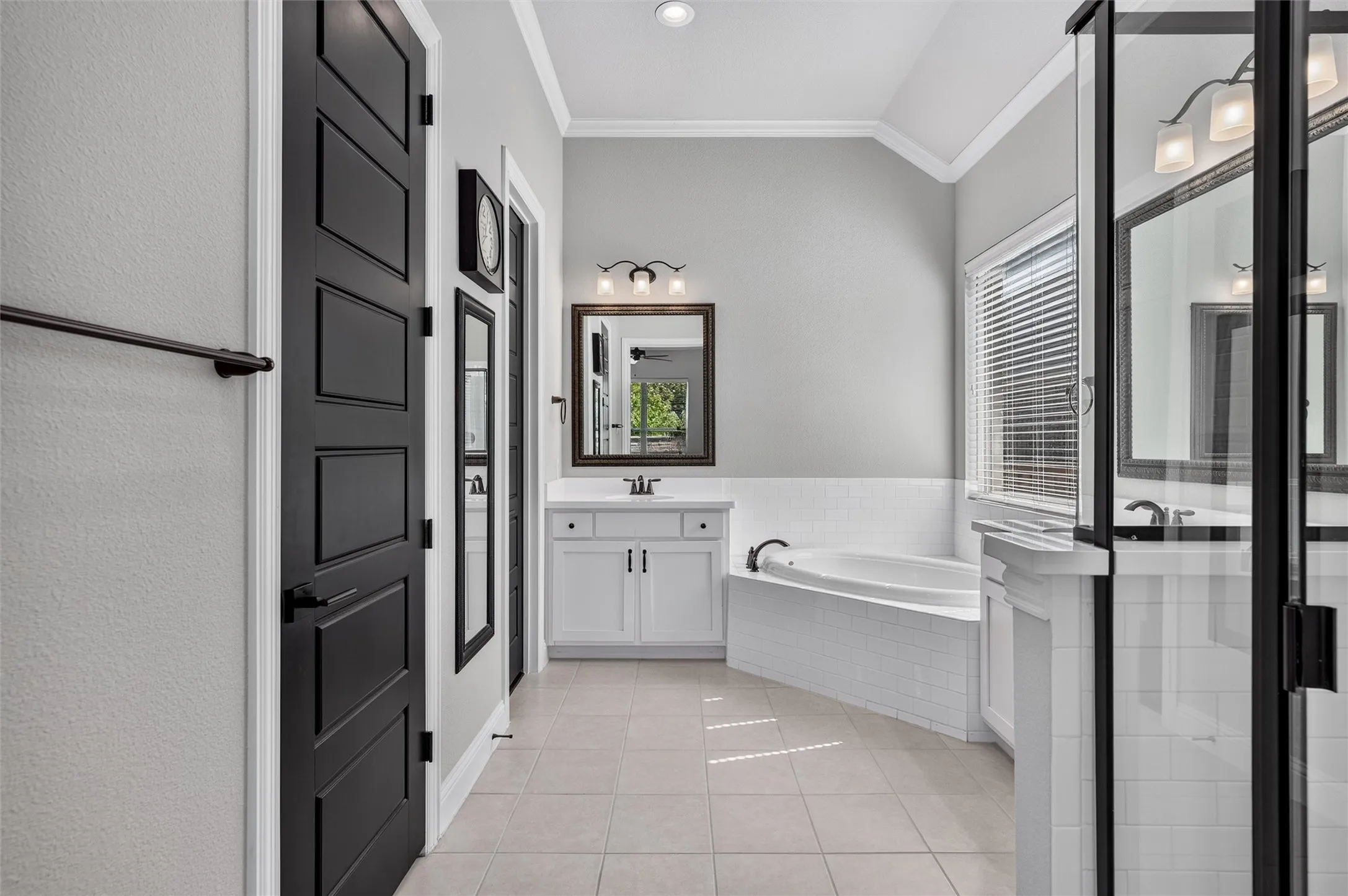 Recessed lighting, wood-finish vanity with countertop, framed mirror, built-in bathtub, and a glass-enclosed shower