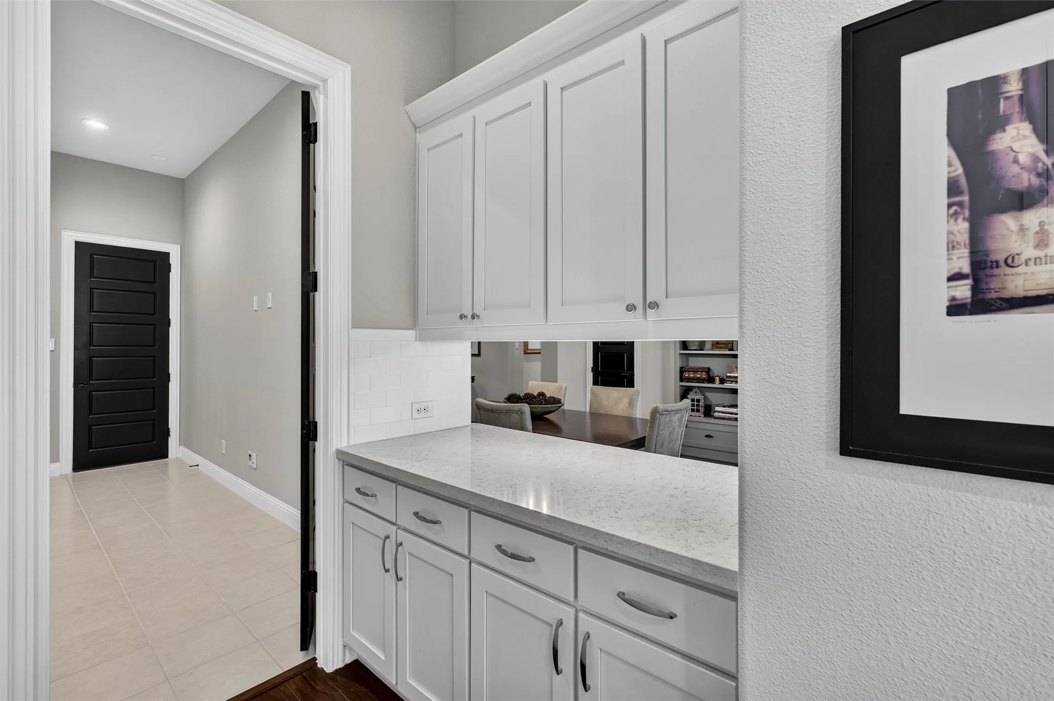 White shaker cabinetry with polished nickel hardware, light-toned countertop, and white subway tile backsplash