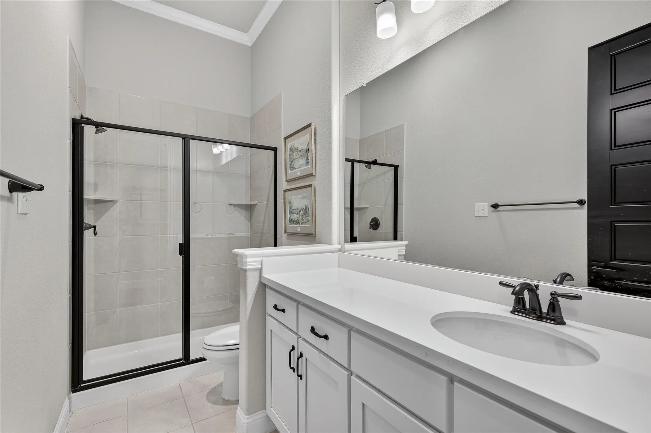 White vanity with multiple storage cabinets, an integrated sink, and a dark bronze faucet