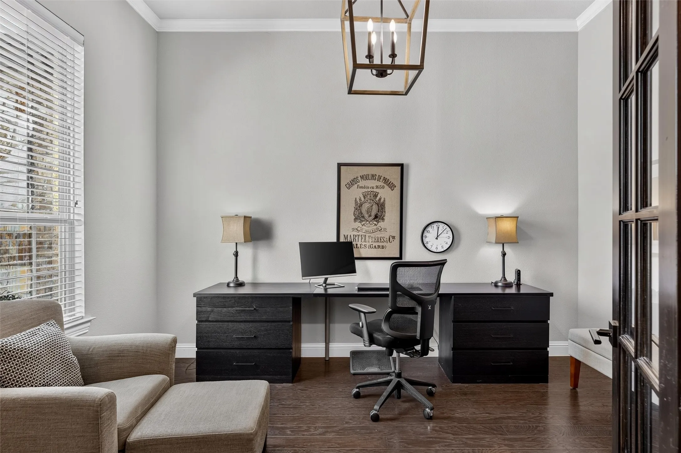 Crown molding, wood-finish flooring, ample natural light, and a large multi-pane window