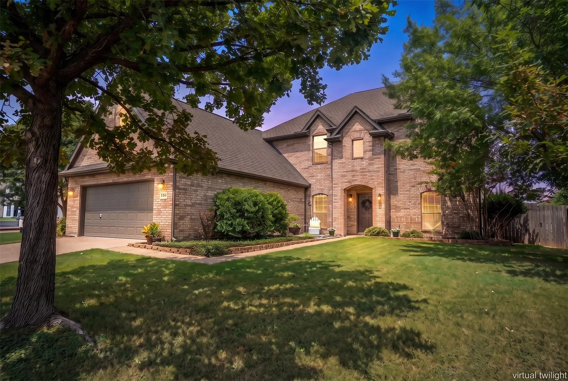 Charming two-story brick home with mature shade tree and manicured front lawn