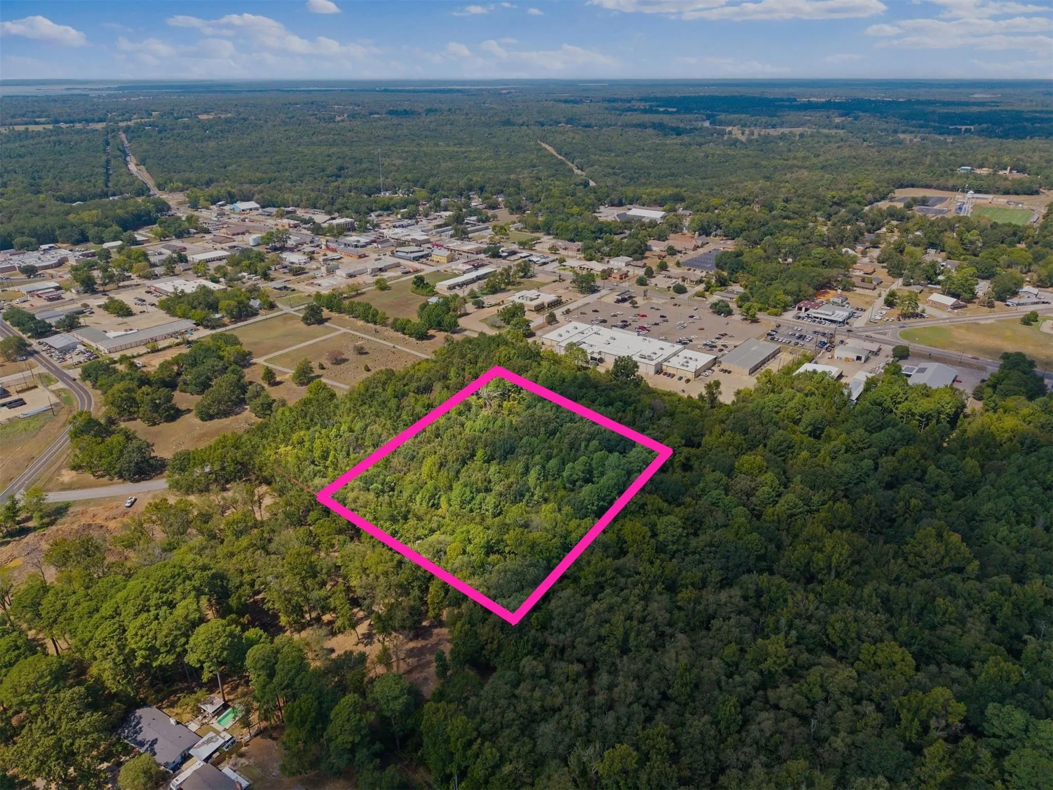 Wooded parcel with surrounding commercial and residential areas