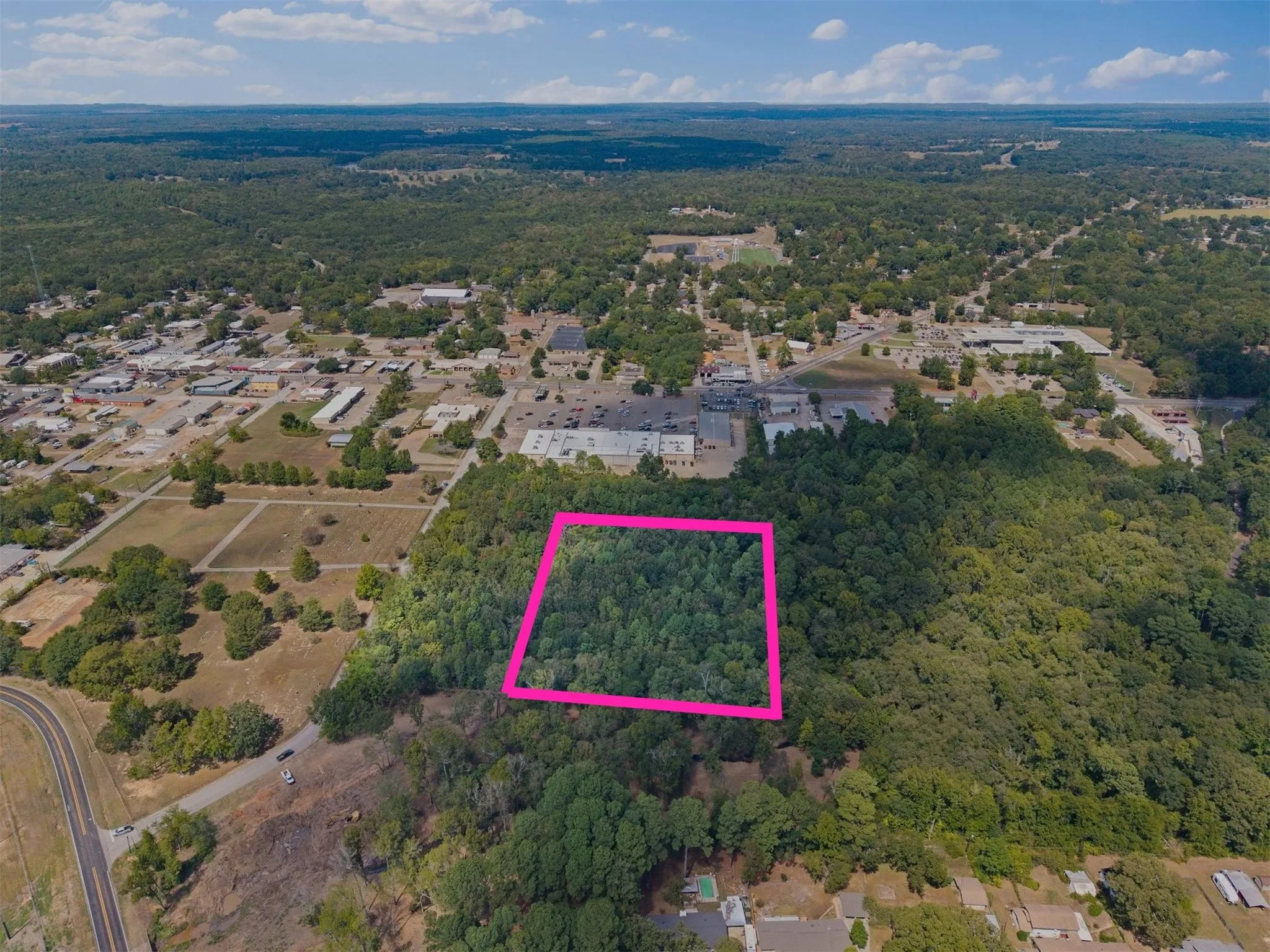 Wooded land parcel with mature trees and surrounding green spaces