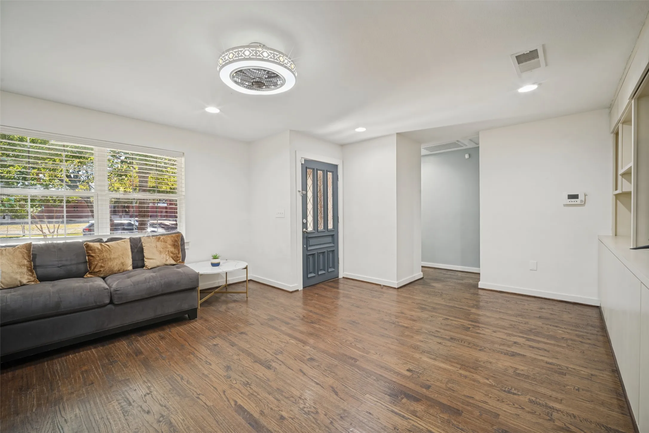 Wood-finish flooring, recessed lighting, and a decorative ceiling fixture
