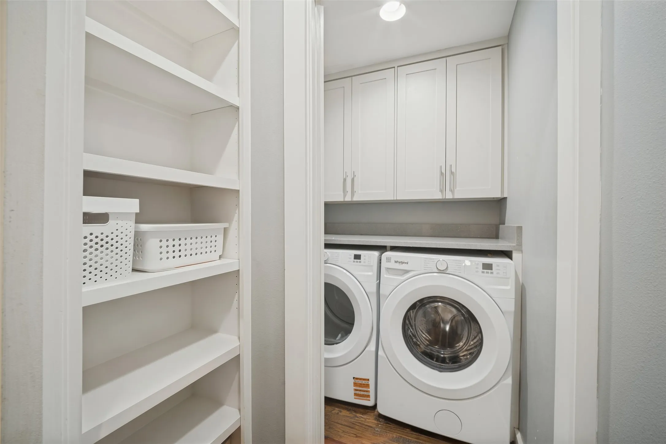 Built-in shelving, white shaker-style cabinetry, and a countertop surface above appliances