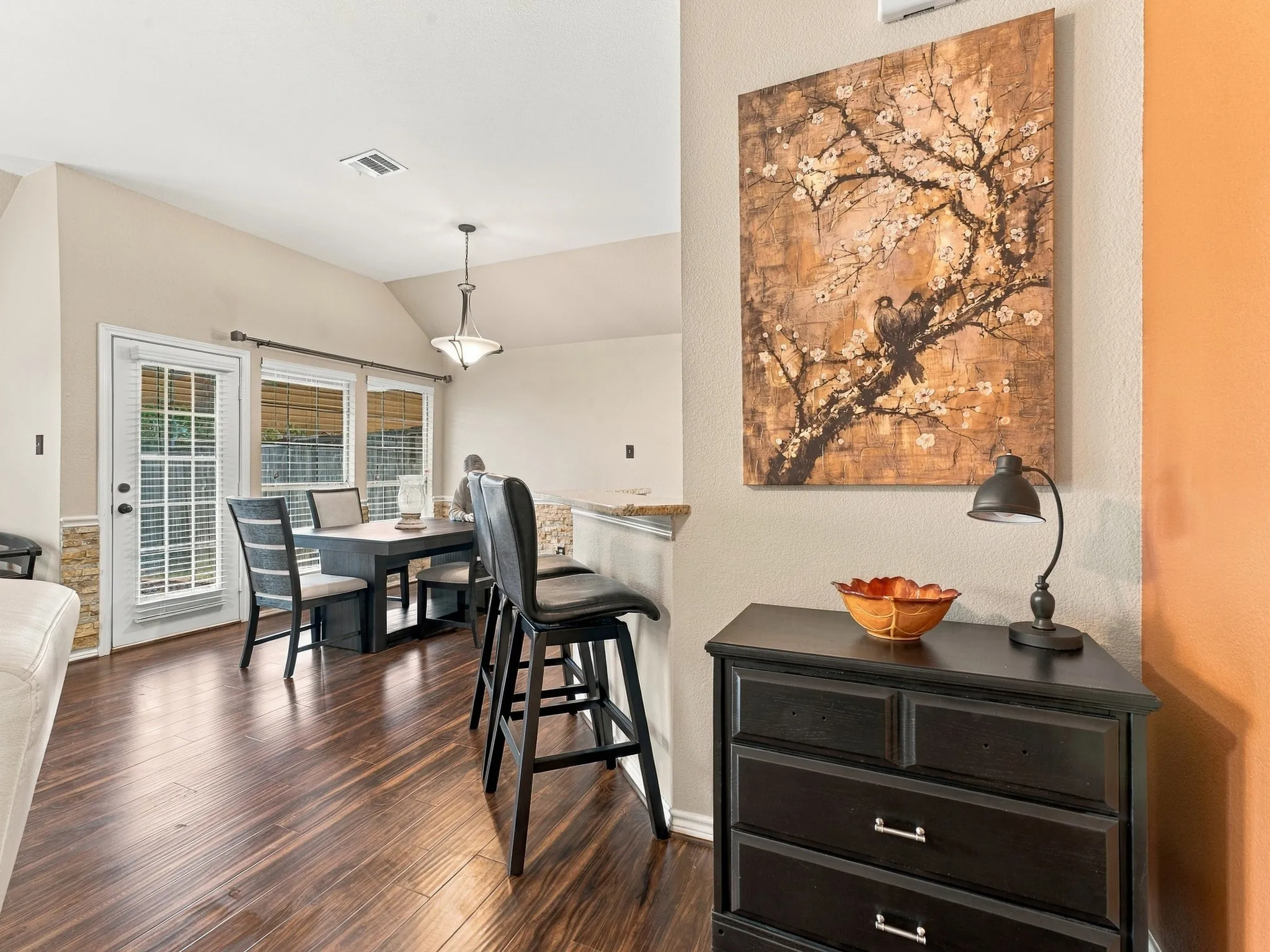Warm wood-finish flooring, vaulted ceiling, and recessed lighting