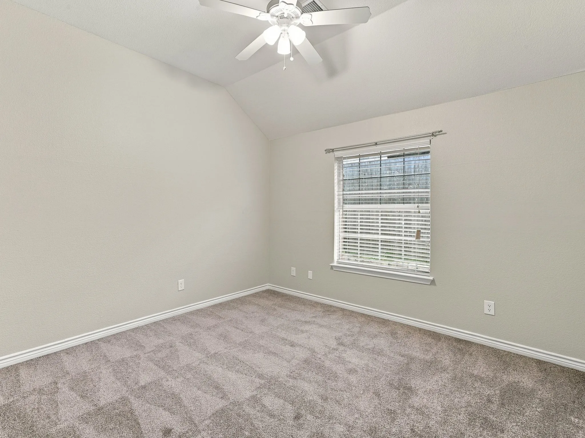 Vaulted ceiling with a ceiling fan, window with blinds, and carpet flooring