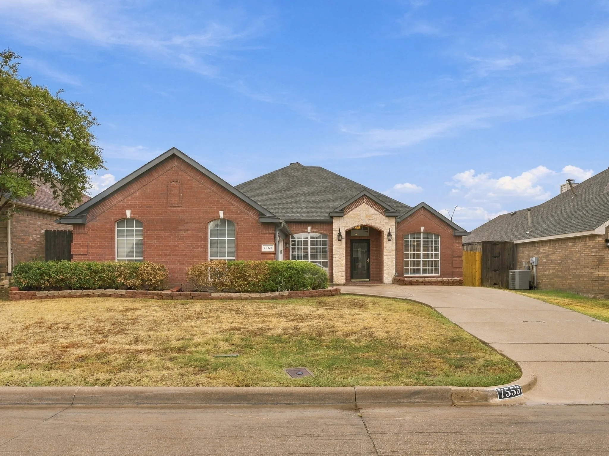 Brick exterior with stone accents and a gabled roofline