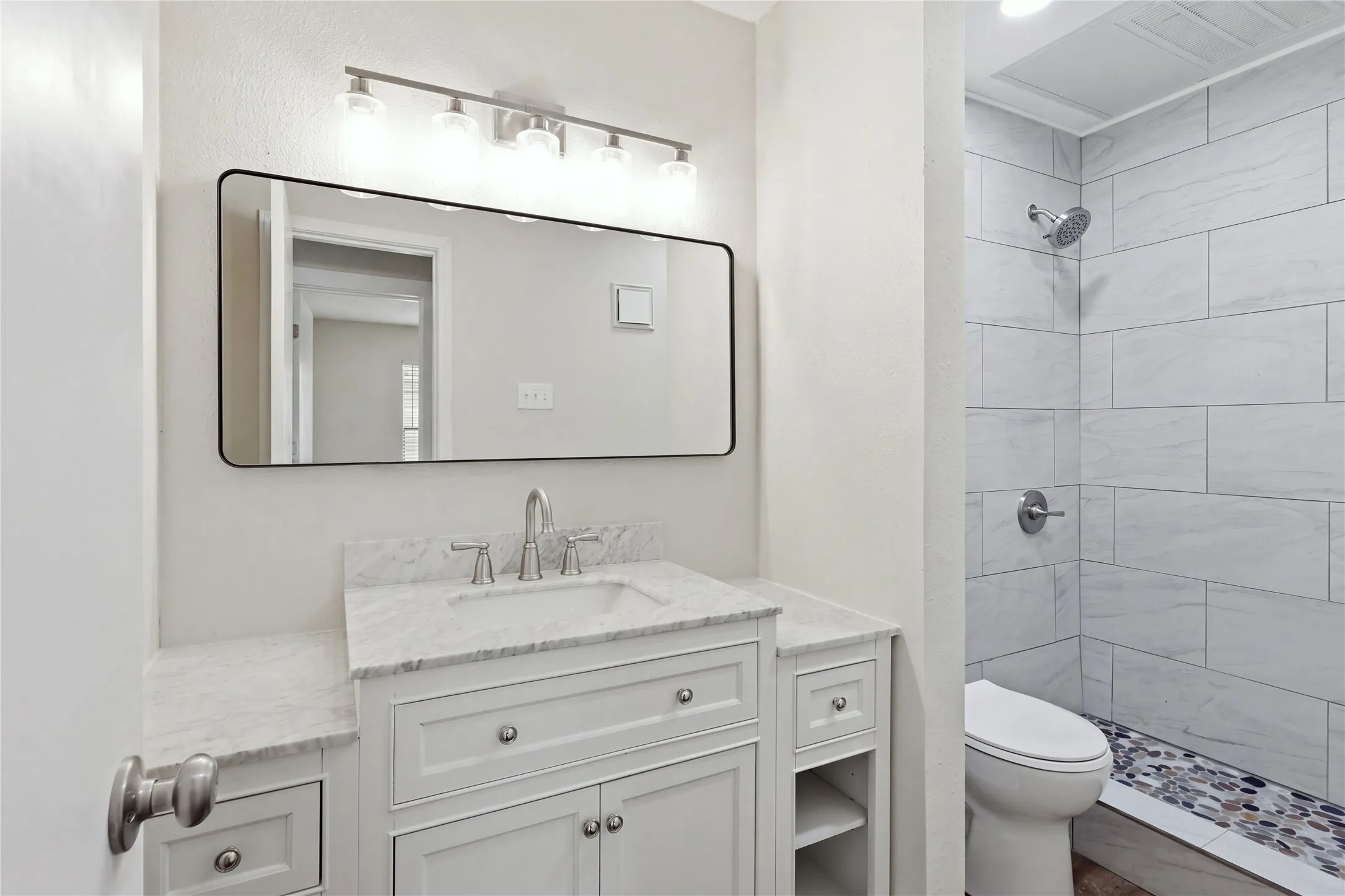 White vanity with undermount sink, marble-finish countertop, and brushed nickel fixtures