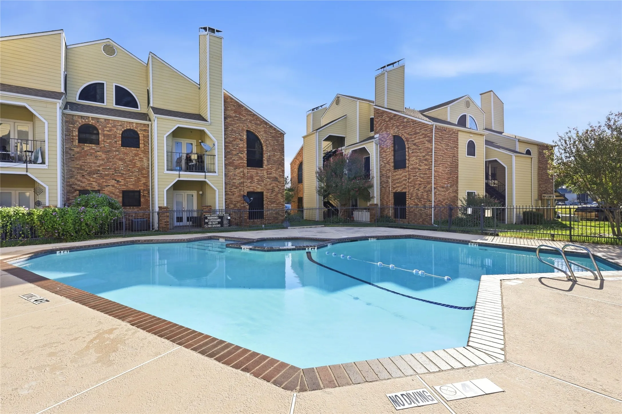 Outdoor swimming pool with integrated spa and concrete decking