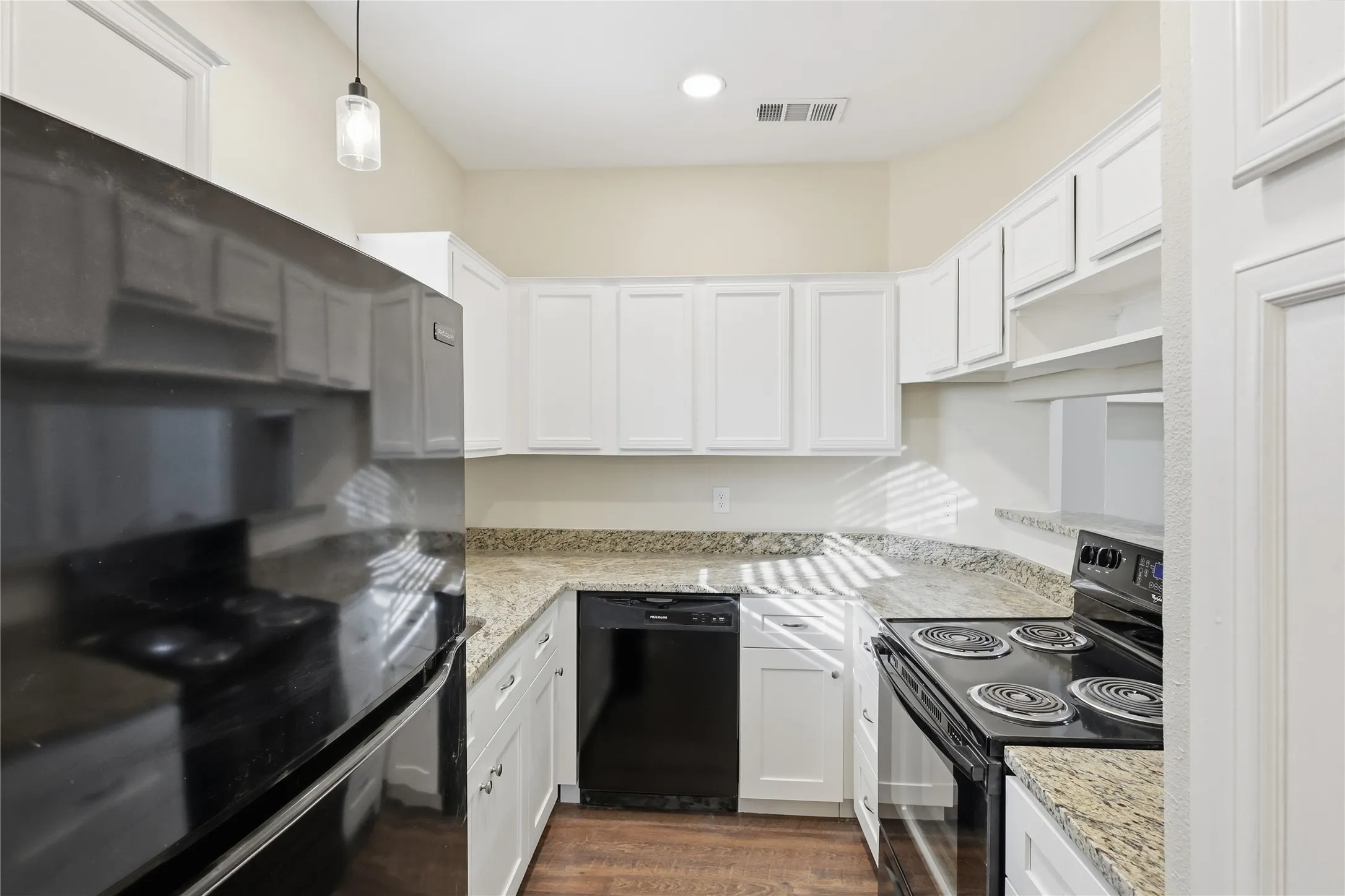 Kitchen featuring white cabinetry, granite-style countertops, wood-finish flooring, a black electric range, and a black dishwasher