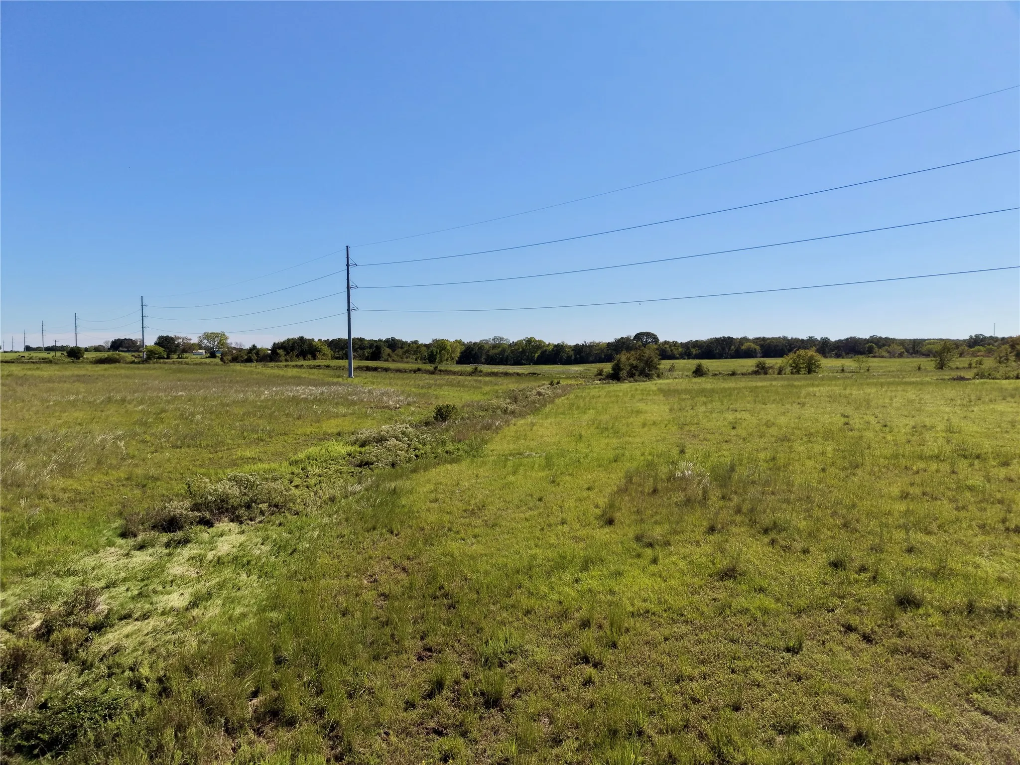 View of the drainage swale and overhead transmission lines crossing the tract.