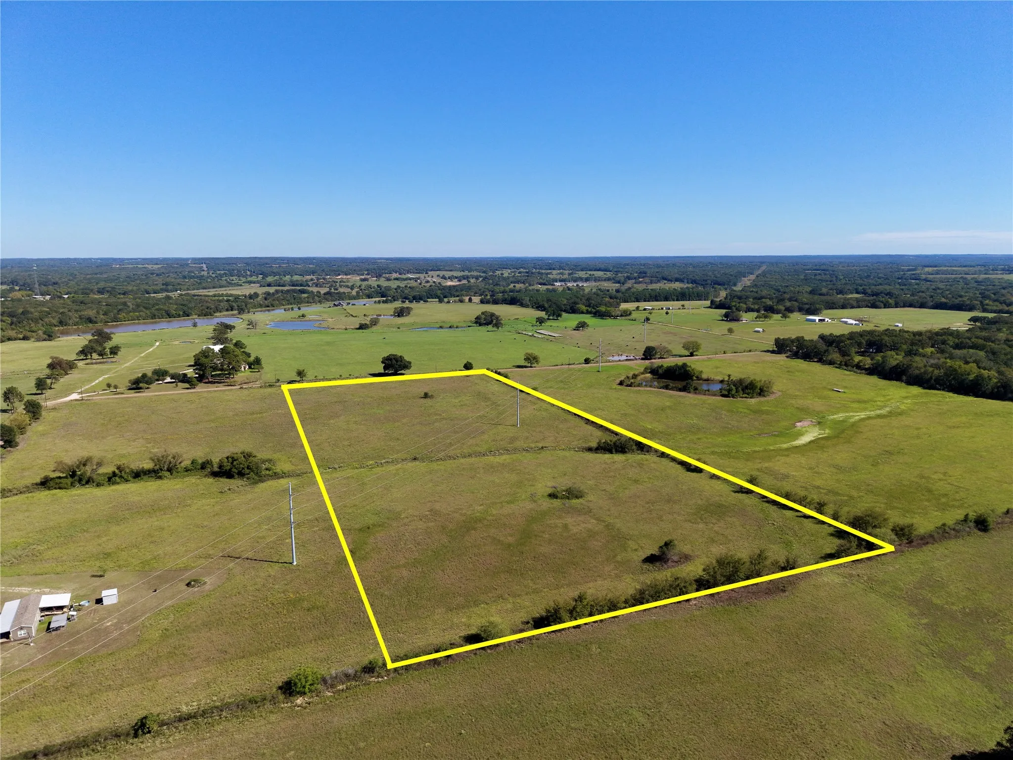 Reverse aerial of the parent tract showing its depth and open pasture; outline is approximate.