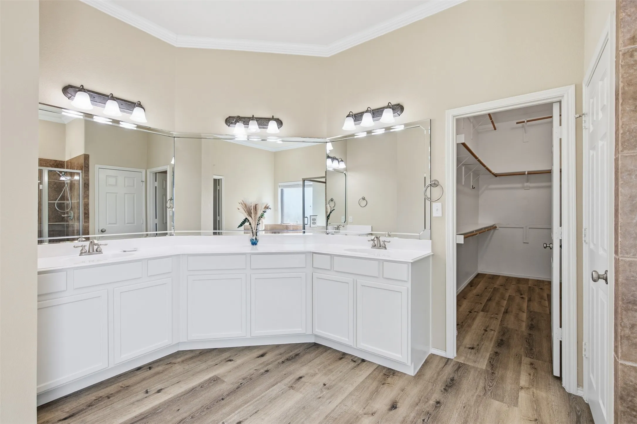 Dual vanity with white cabinetry, wall-mounted mirrors, and chrome fixtures
