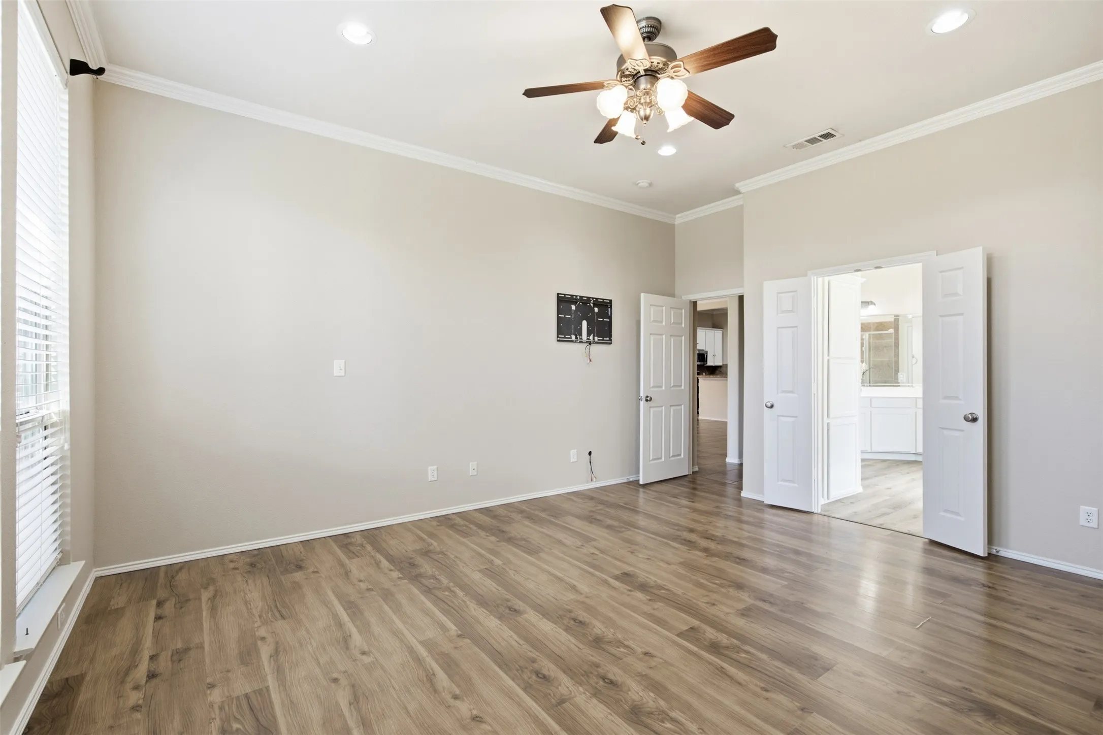Vaulted ceilings, wood-finish flooring, ceiling fan with integrated lighting, recessed lighting, and white trim