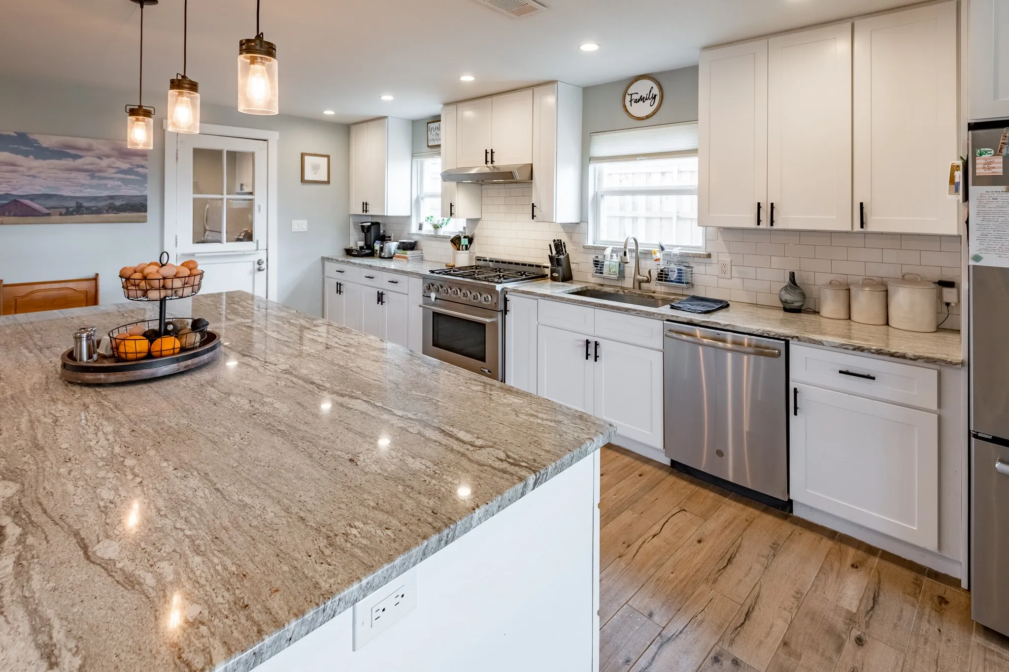 Kitchen with stainless steel appliances, gas stove, kitchen island, updated cabinets with hardware.