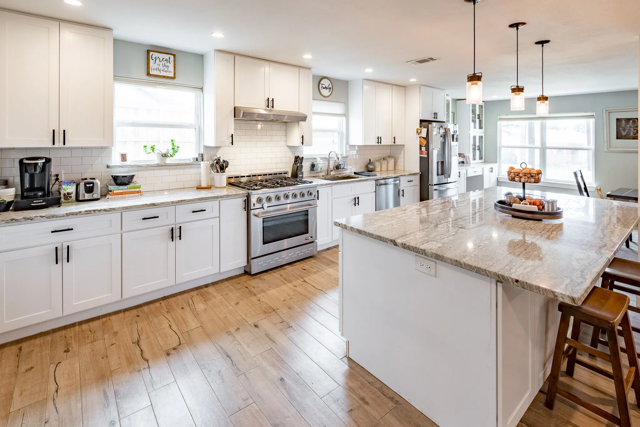 Kitchen with stainless steel appliances, gas stove, kitchen island, updated cabinets with hardware.