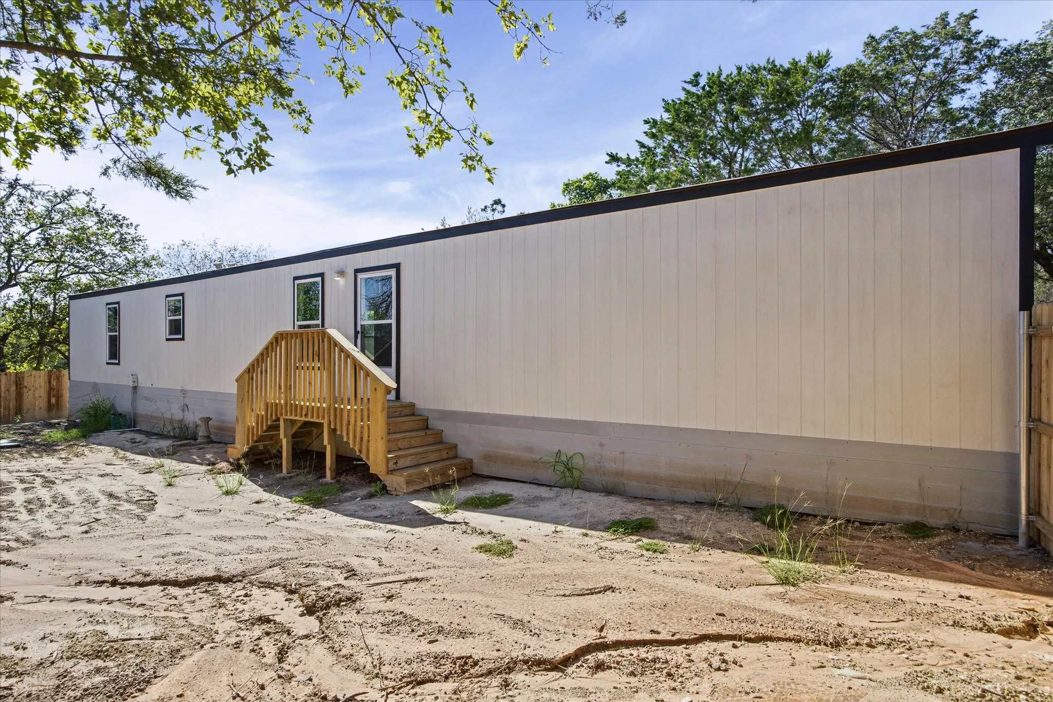 Exterior siding with vertical paneling, black trim, and multiple windows