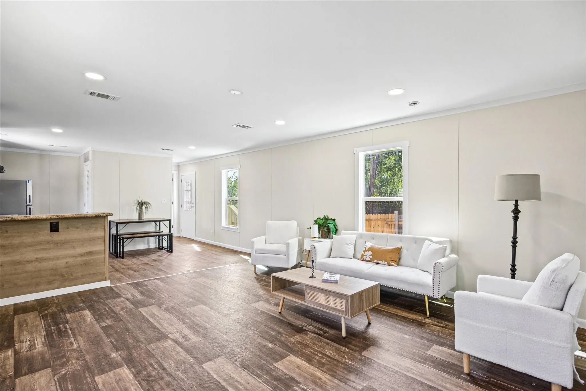 Open-concept living area featuring wood-finish flooring, recessed lighting, and light-toned walls