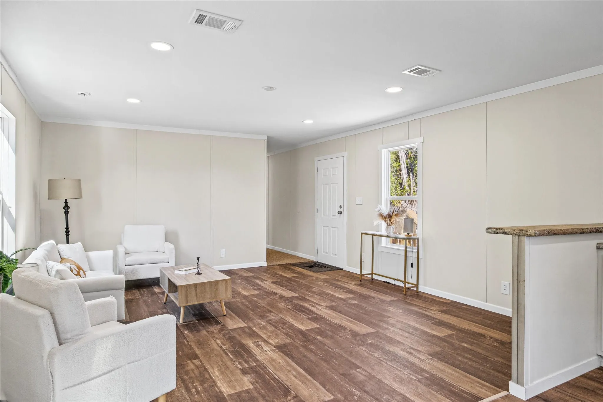 Wood-finish flooring, recessed ceiling lighting, light-toned walls, and white trim