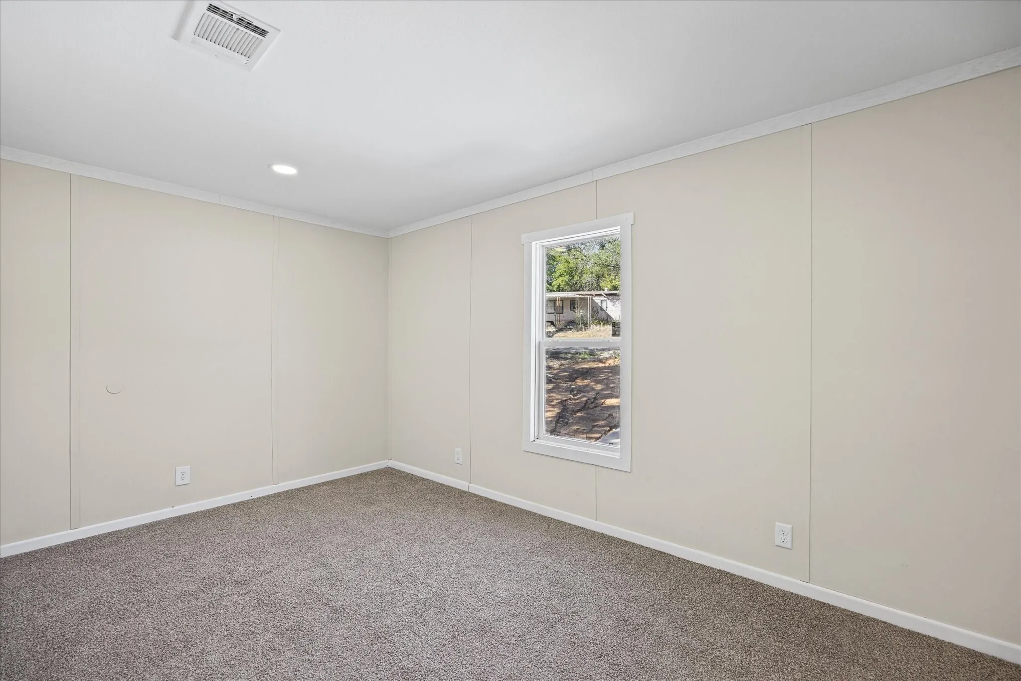 Neutral wall finishes with white trim, recessed ceiling lighting, and carpet flooring