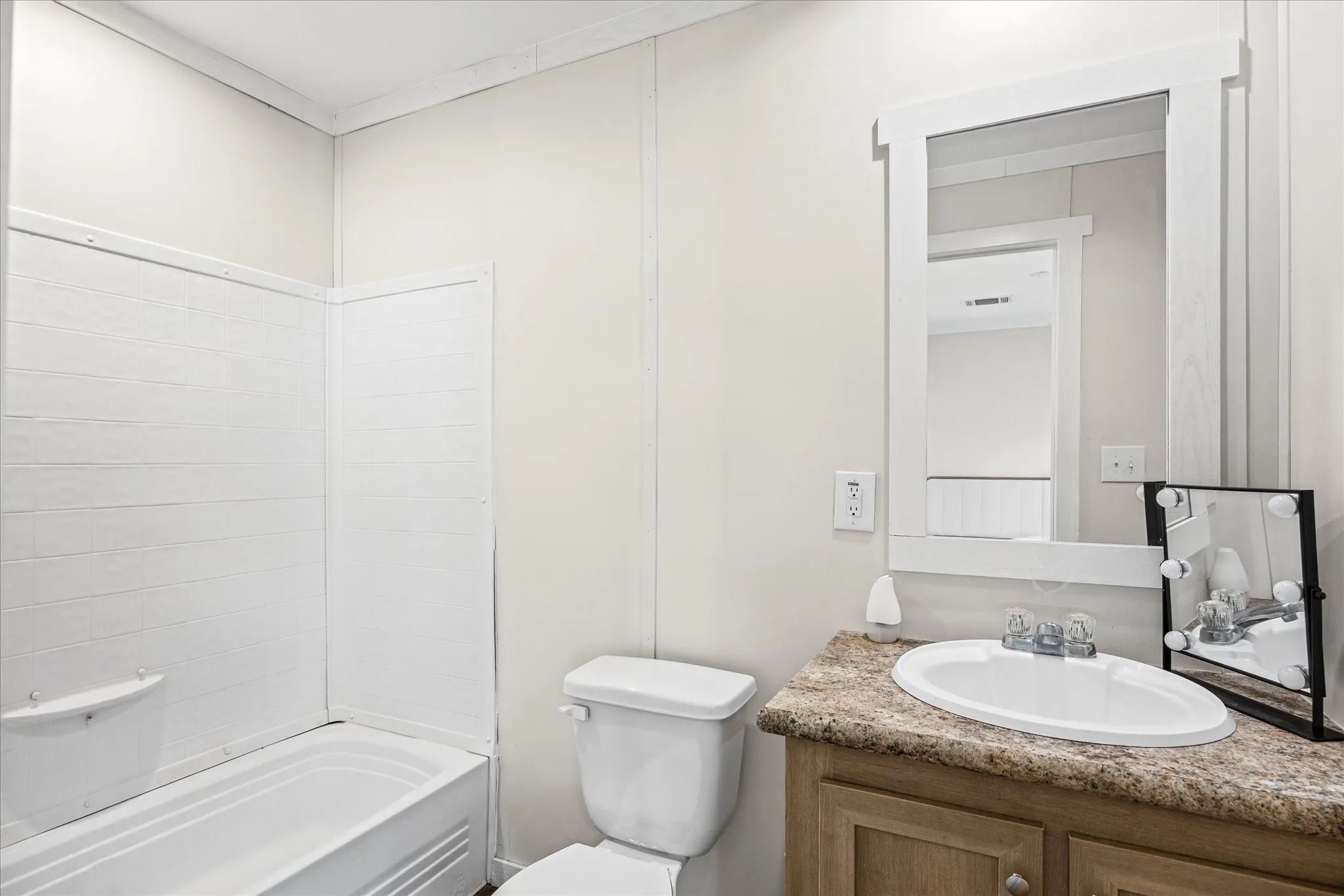 White tub and shower combination with textured wall surround