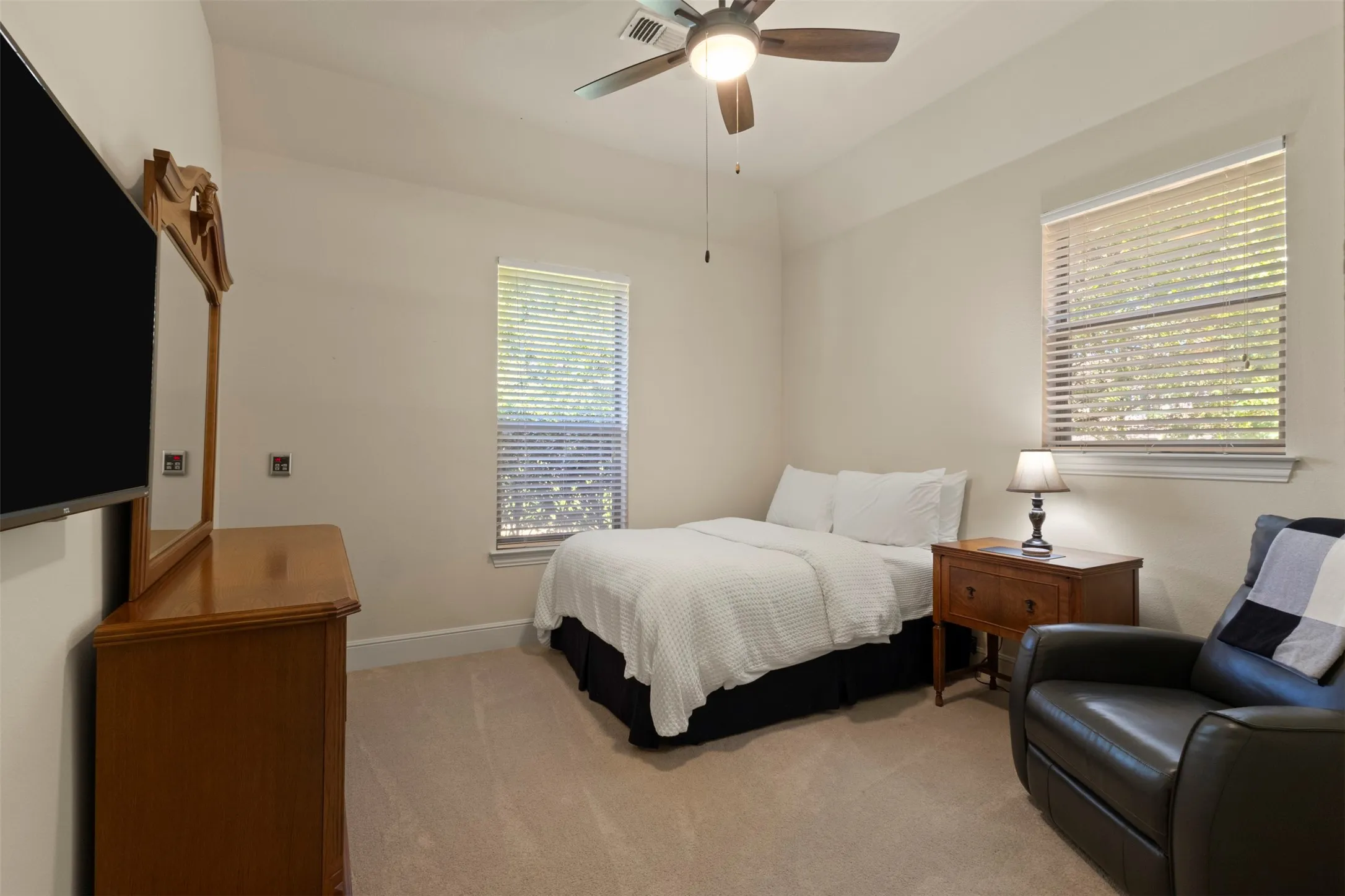 Neutral wall paint, carpet flooring, a ceiling fan with integrated lighting, and a window with blinds