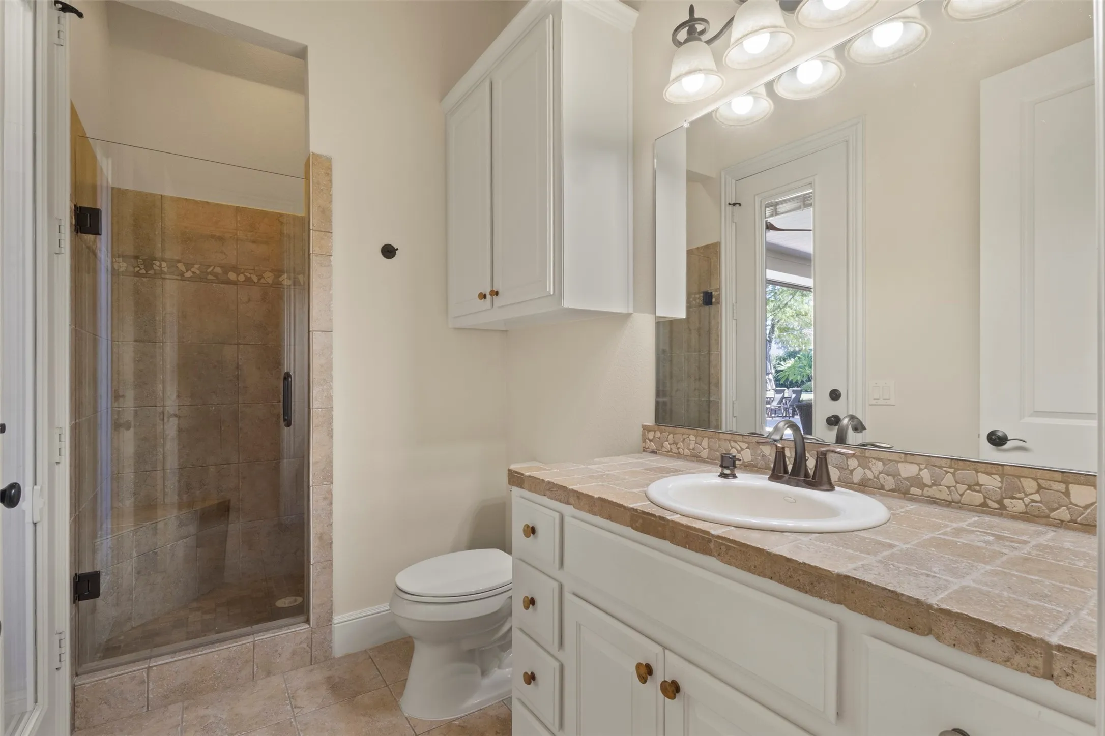 White vanity with a tile countertop, integrated sink, and an oil-rubbed bronze faucet