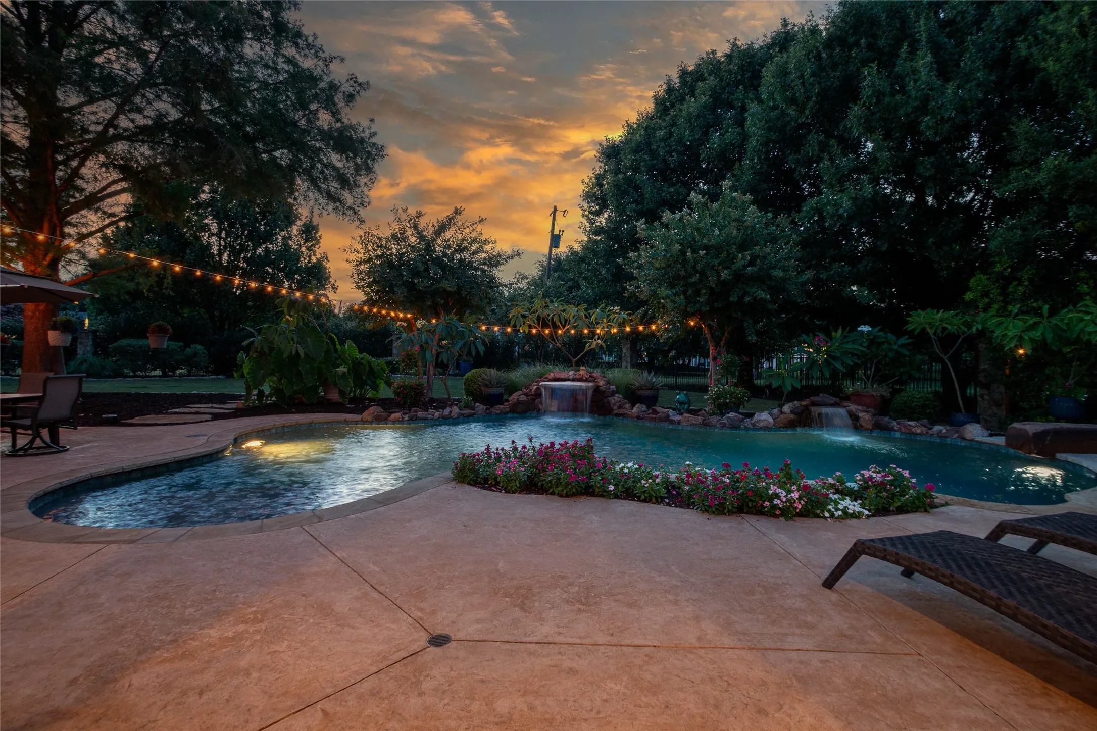 Expansive custom pool with integrated spa and rock waterfall features
