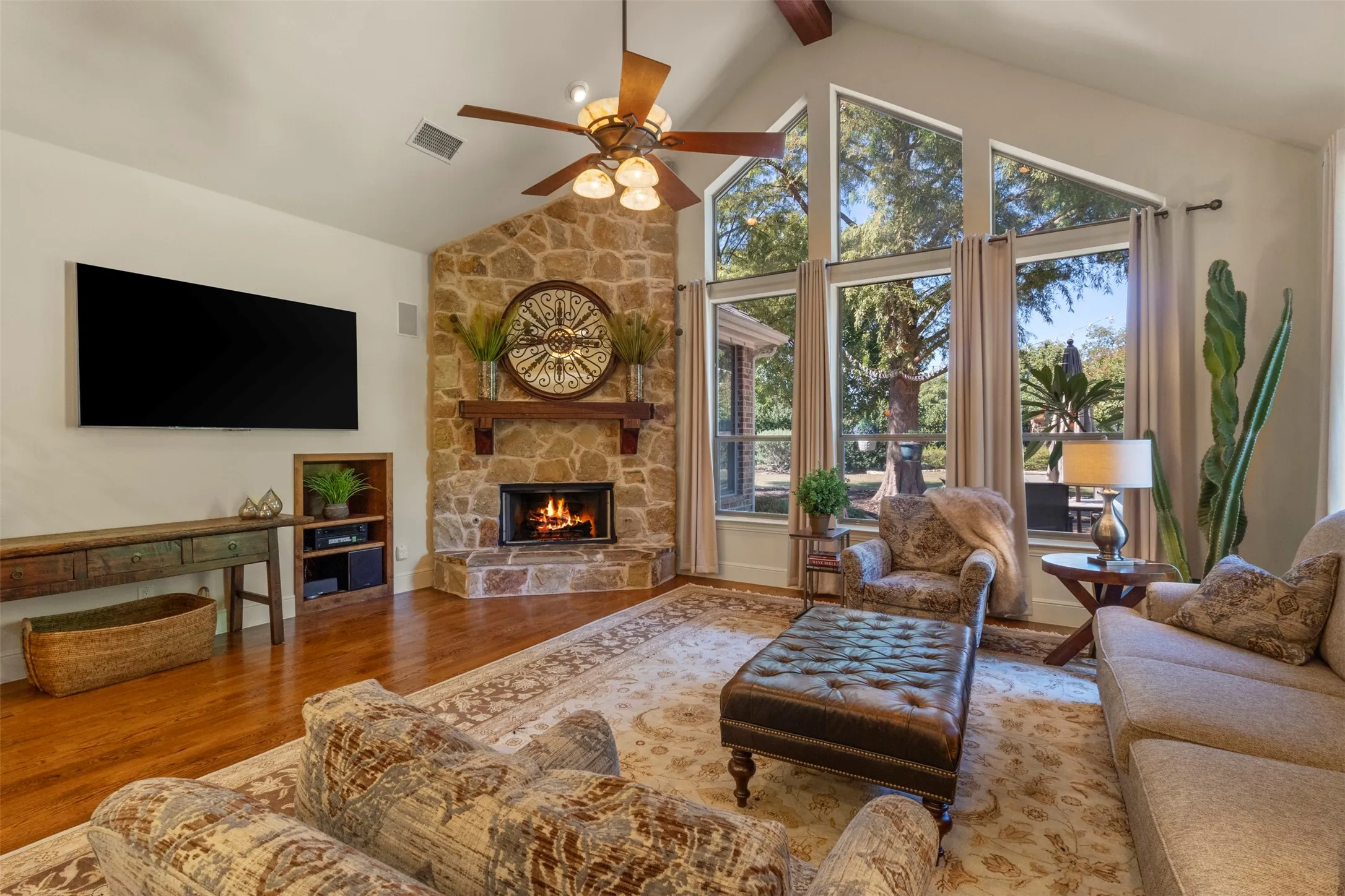 Vaulted ceiling with exposed wood beams and a ceiling fan