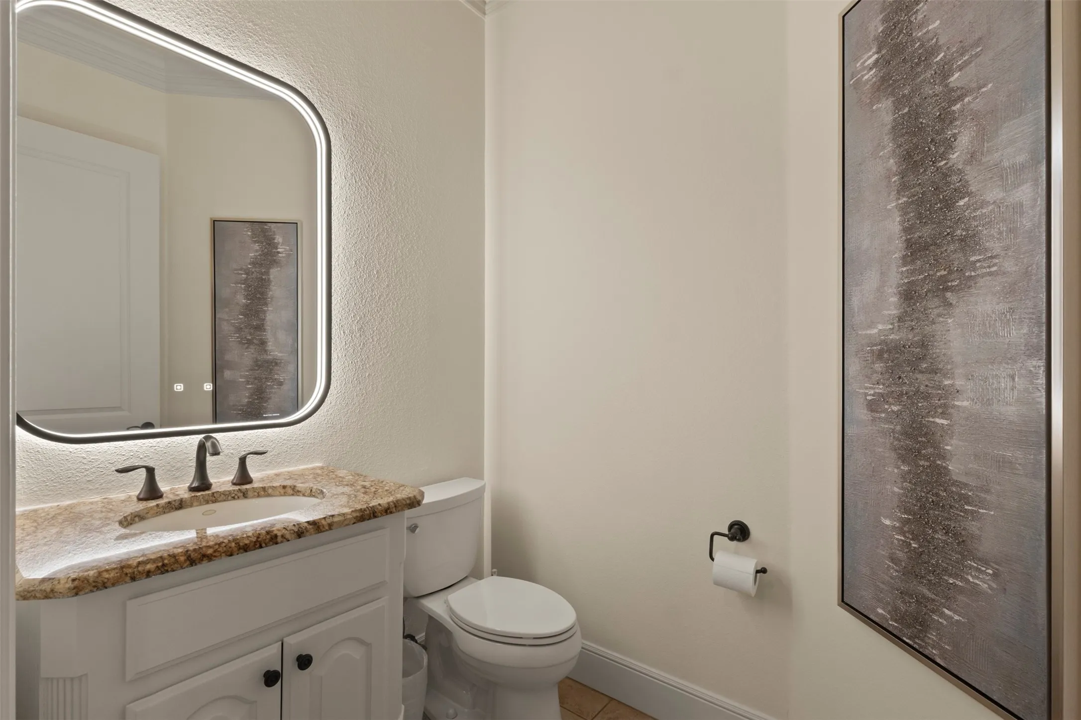White vanity with a granite countertop and an undermount sink