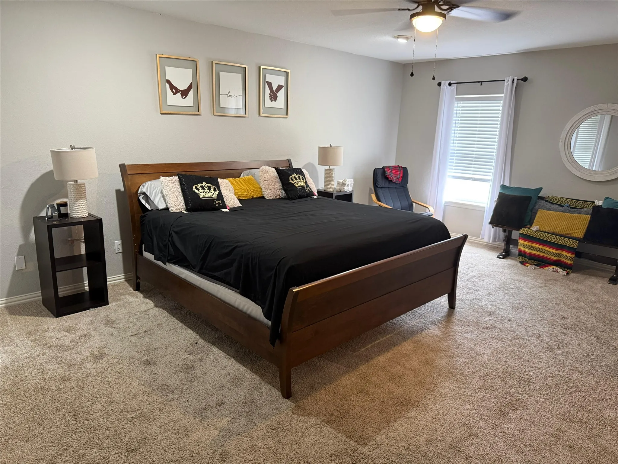 Neutral-toned wall paint, ceiling fan with integrated lighting, window with blinds and drapes, and wall-to-wall carpeting