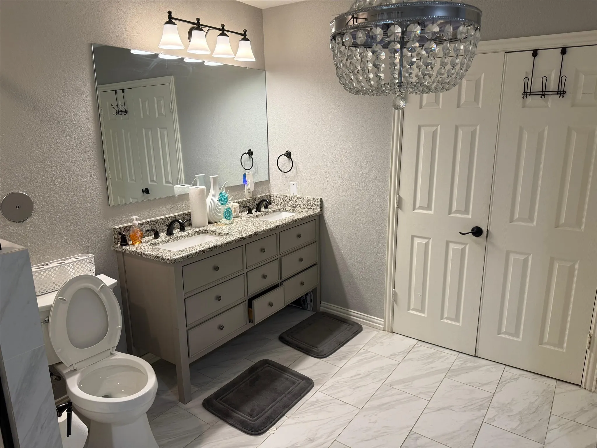 Double vanity with granite countertops, dual undermount sinks, and dark bronze fixtures