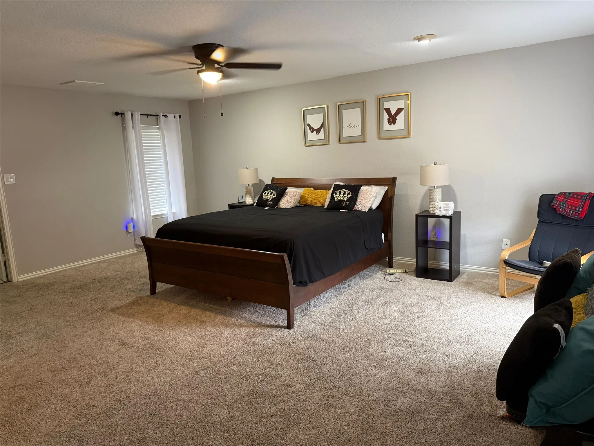 Wall-to-wall carpeting and a ceiling fan with integrated lighting