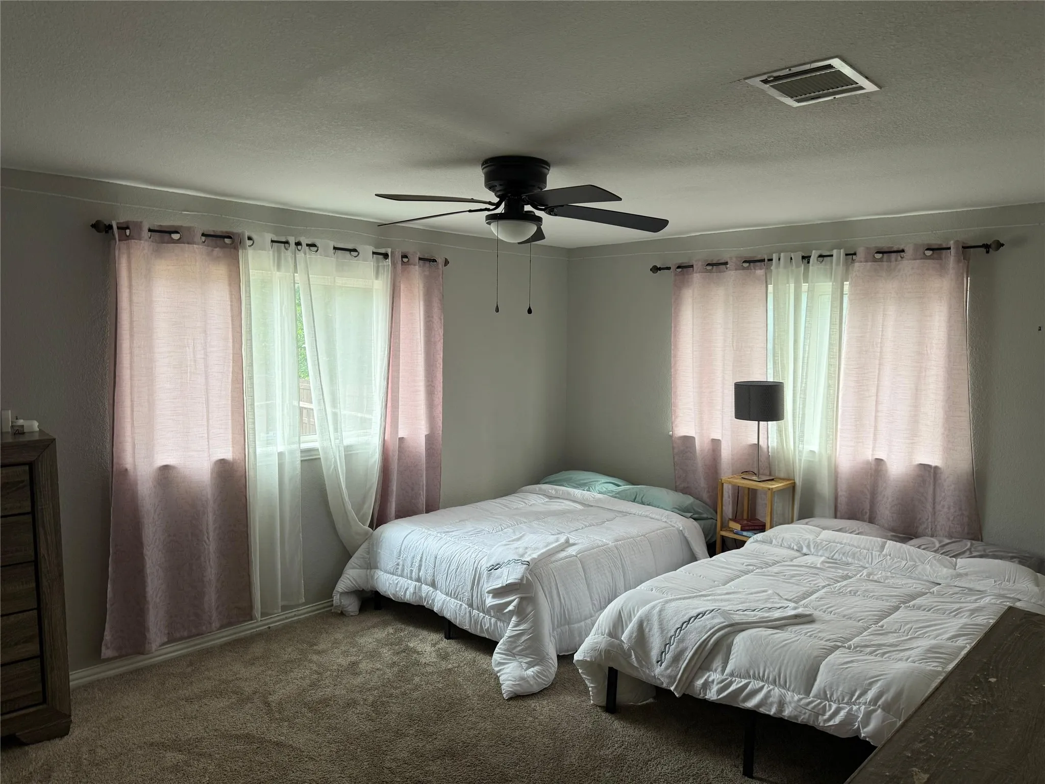 Wall-to-wall carpeting and a ceiling fan with integrated lighting