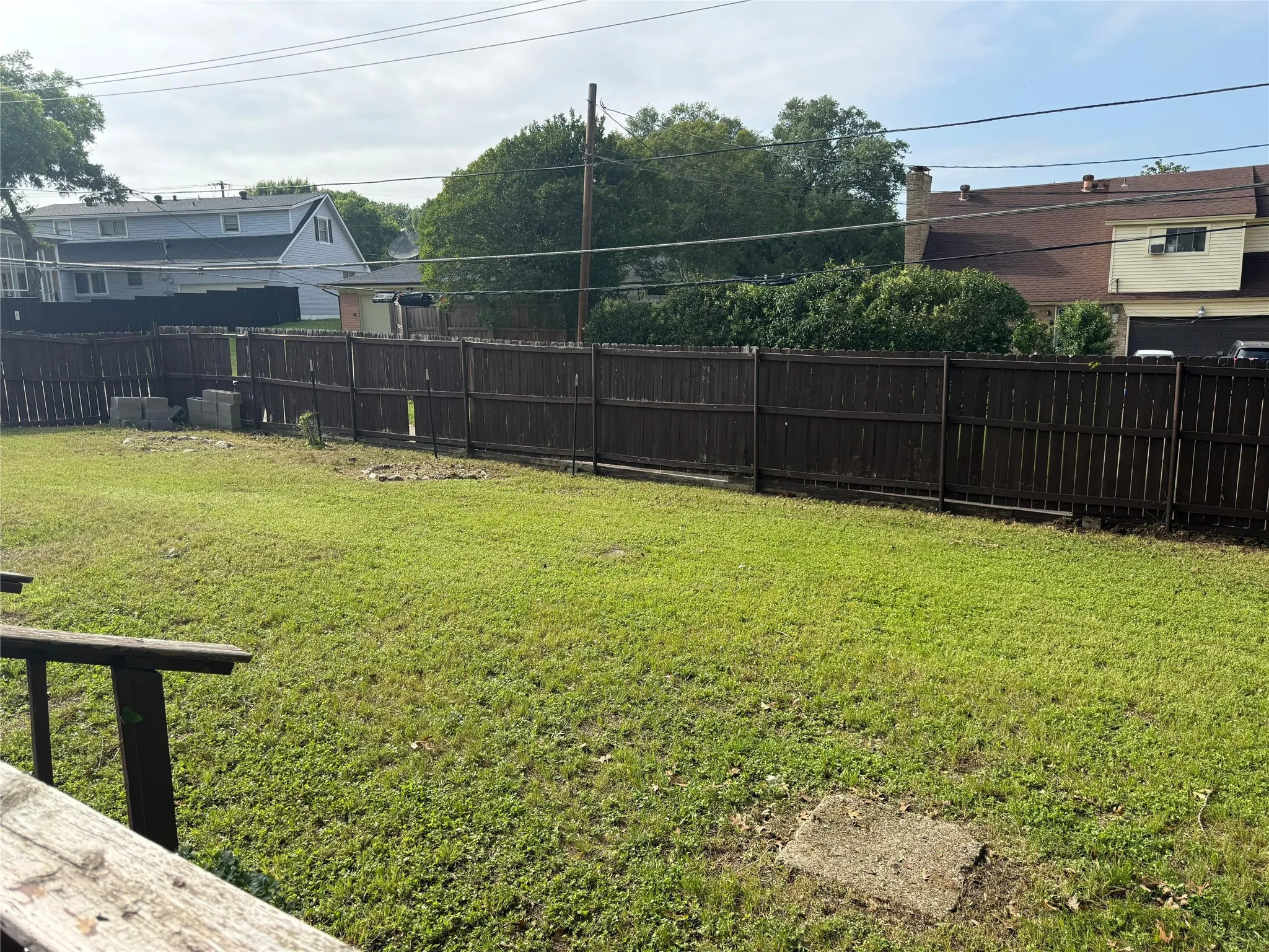 Expansive rear yard featuring a wood privacy fence and grassy area
