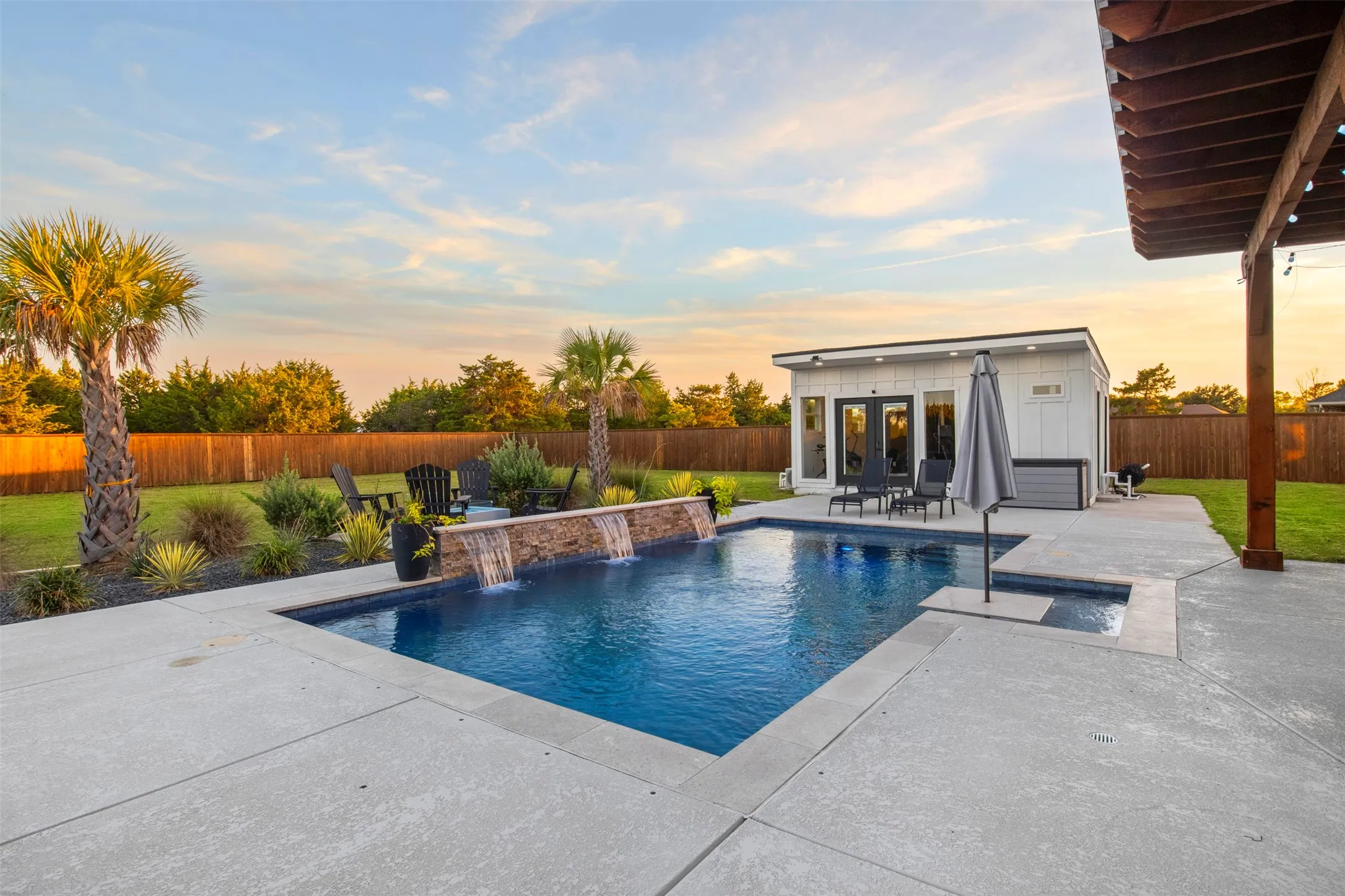 Resort-style pool featuring a tanning ledge, margarita table and sheer-descent water features.