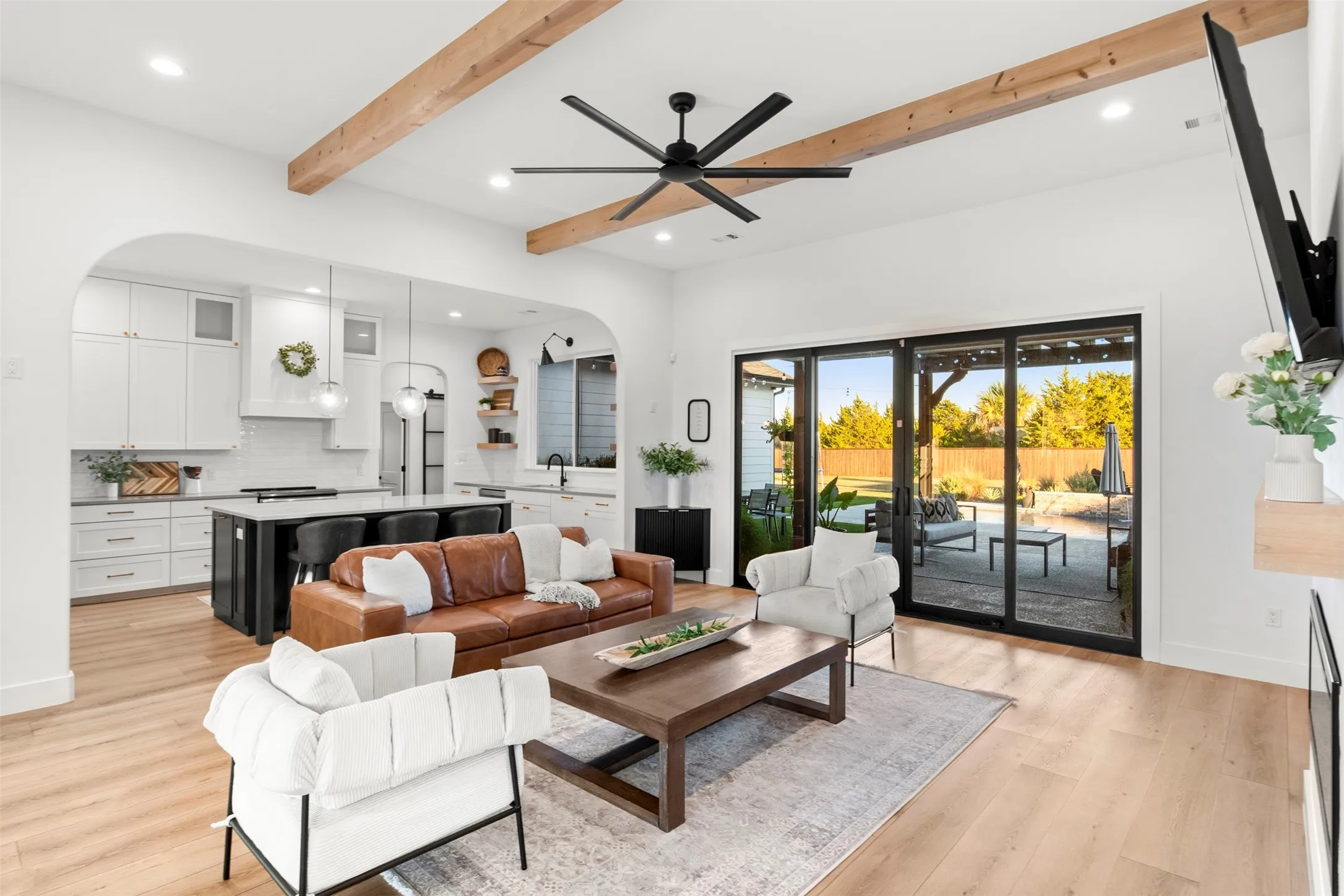 Natural wood ceiling beams, warm wide-plank flooring and expansive glass doors set the tone for the home.