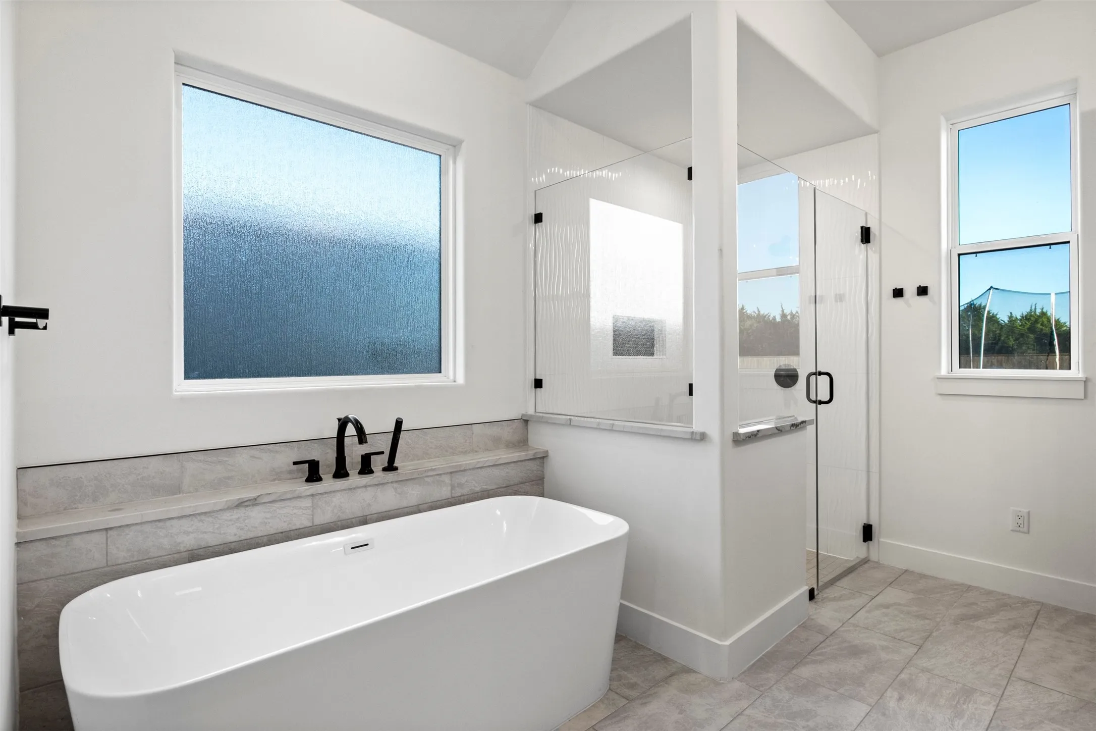 Freestanding soaking tub, separate walk-in shower and abundant natural light.