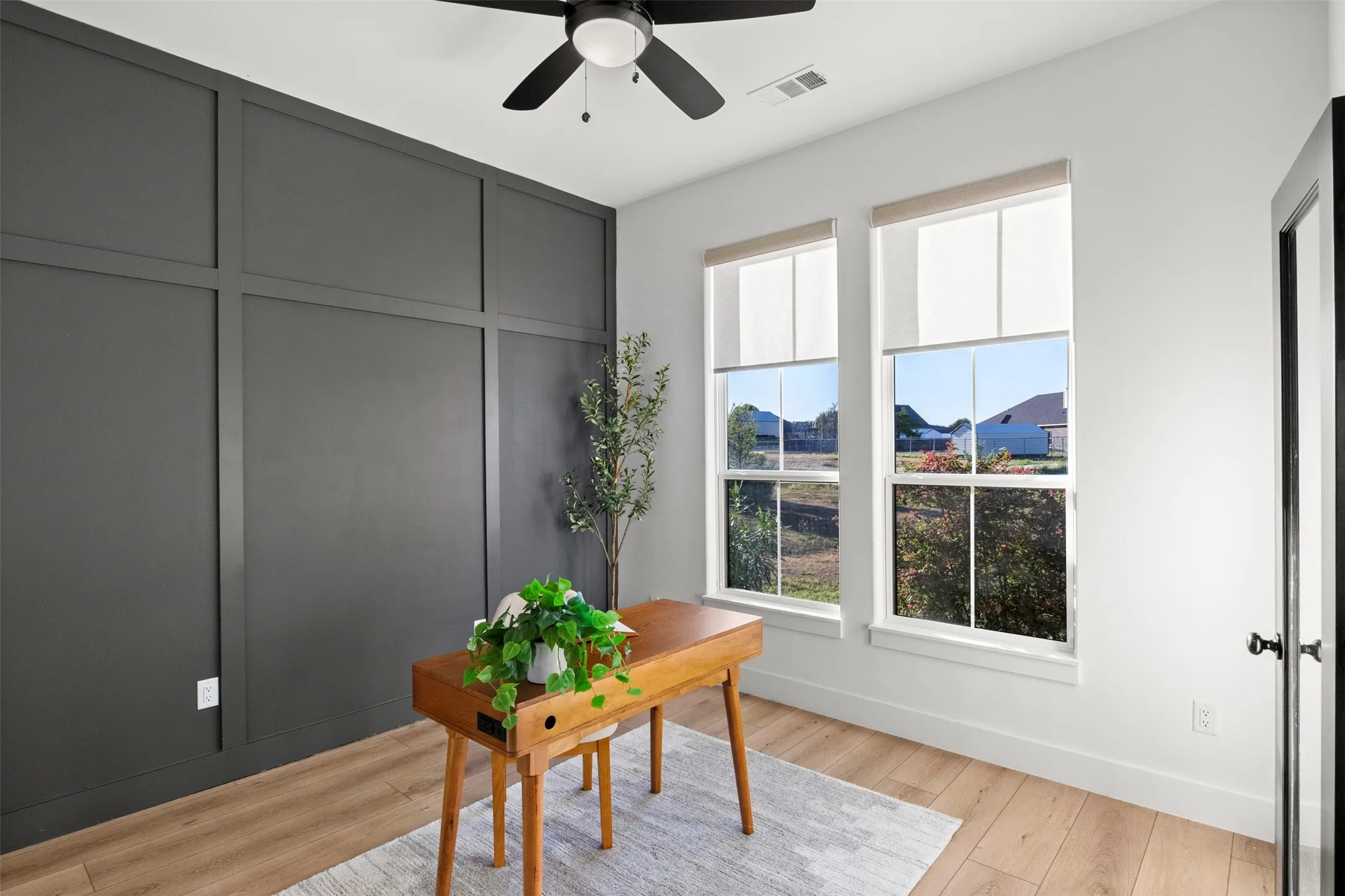 Dedicated home office with glass-paneled double doors, accent wall and natural light with closet for added storage - valuable space beyond the bedrooms.