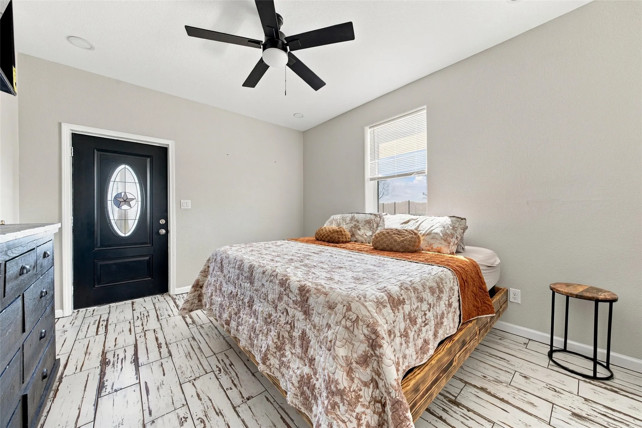 Distressed wood-finish flooring, recessed lighting, and a black ceiling fan with integrated lighting
