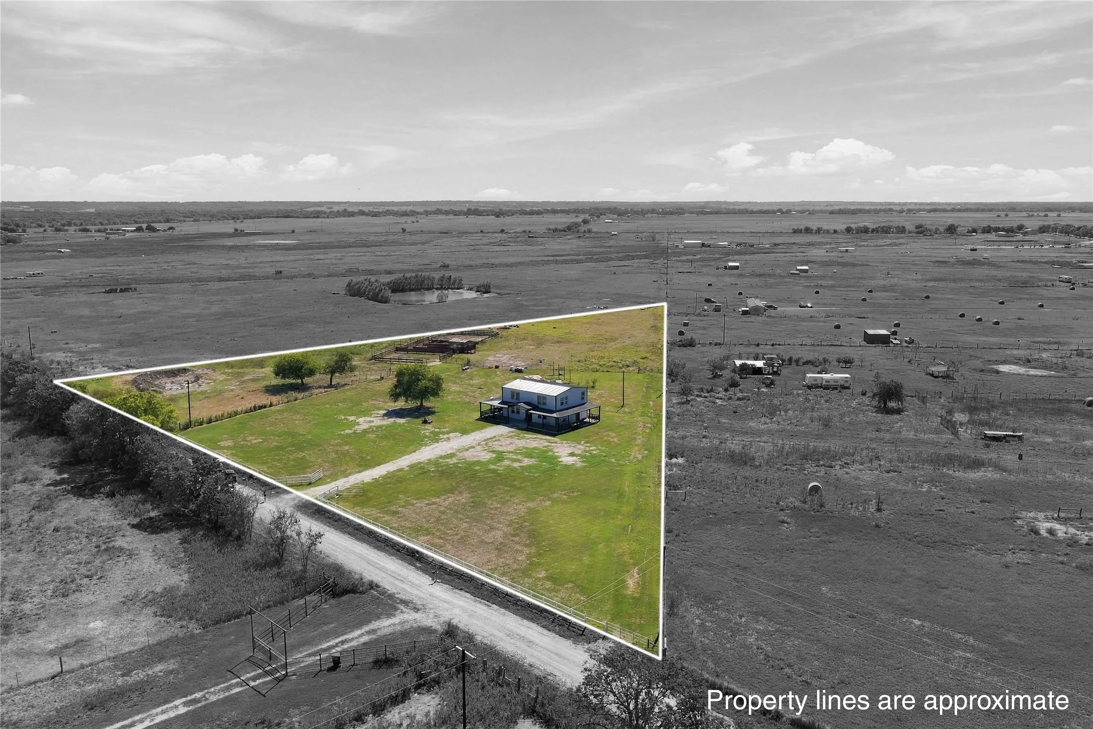 Expansive land parcel featuring a modular residence, mature trees, and a dirt road frontage