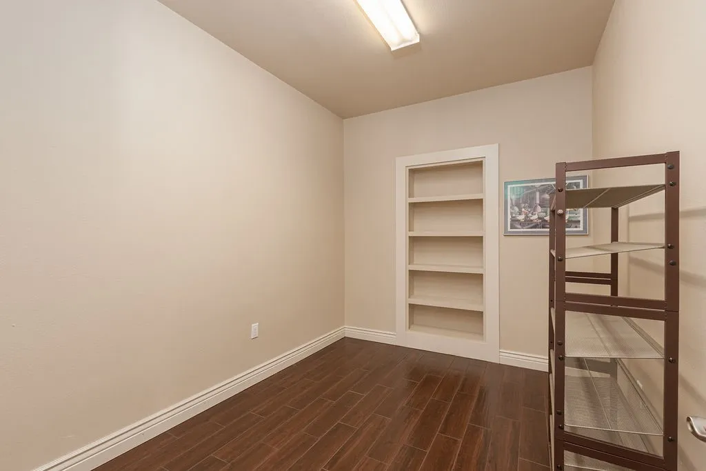 Wood-finish flooring with recessed lighting, ceiling fan, and crown molding