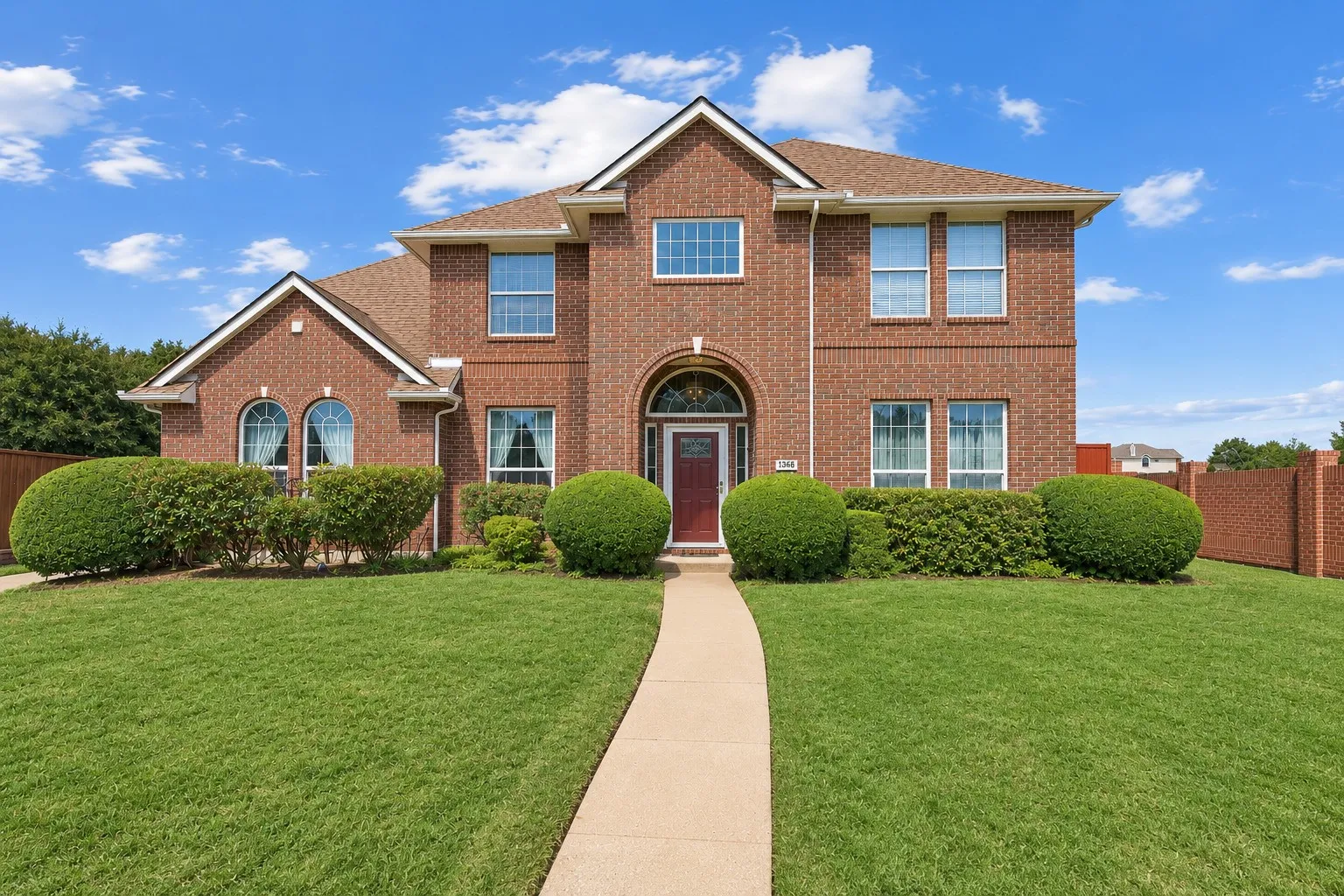 Brick exterior with arched entry, complementing windows, and an arched transom over the front door