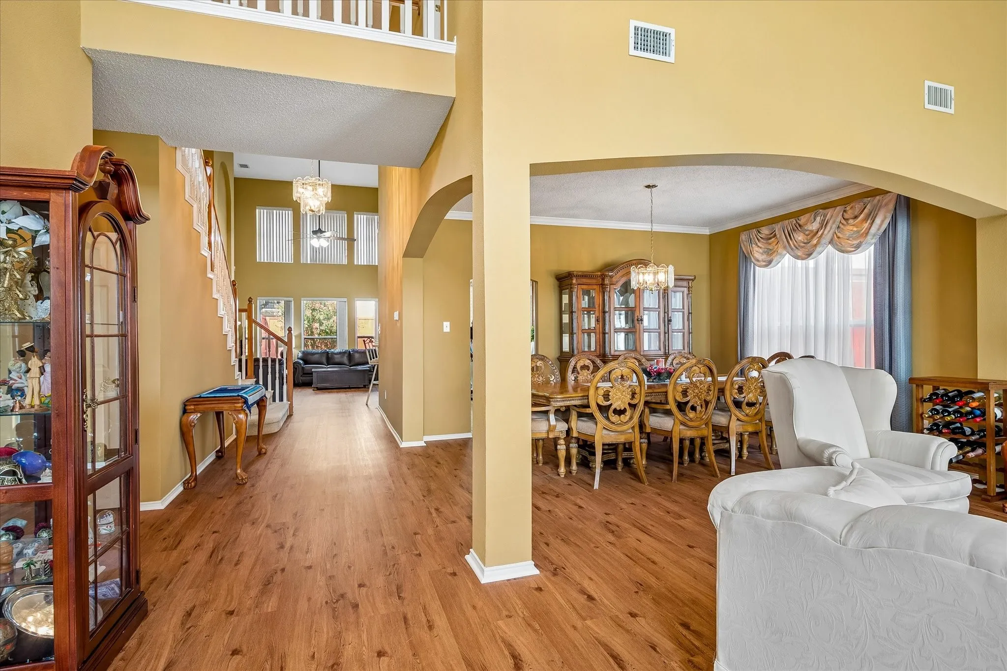 Wood-finish flooring and arched doorways define the open-concept design