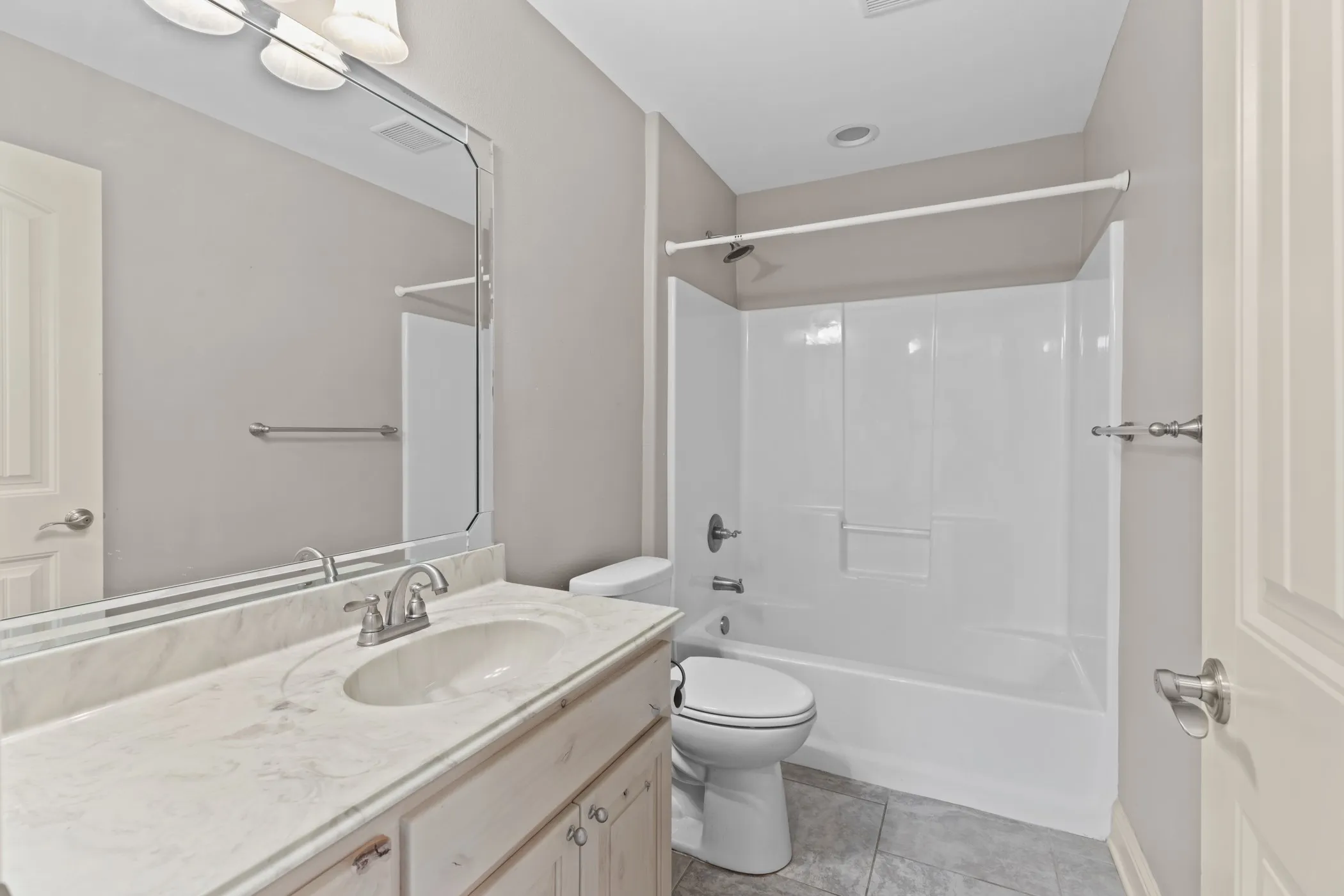 Single vanity with light-toned countertop and undermount sink