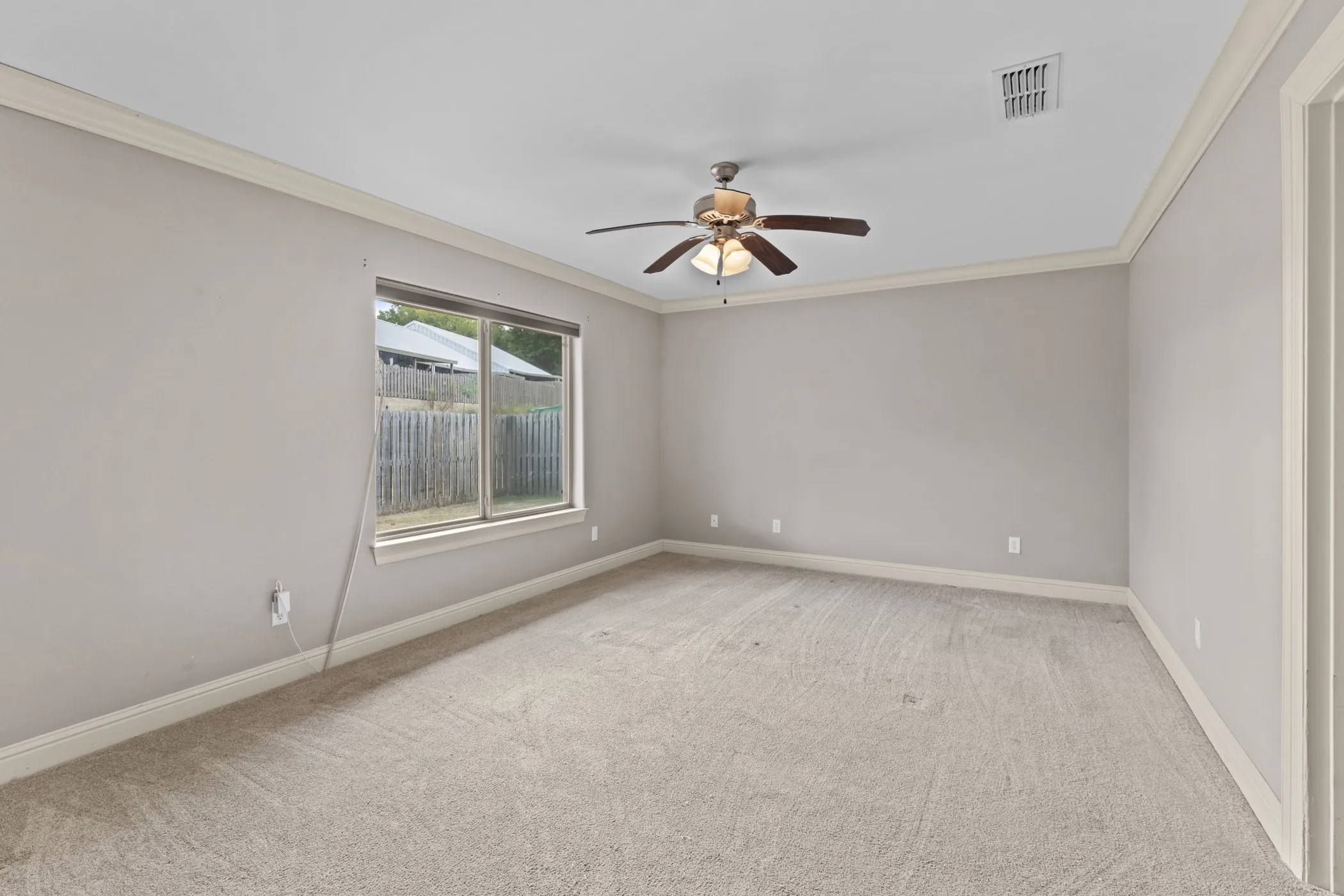 Wall-to-wall carpeting, crown molding, and a ceiling fan with integrated lighting