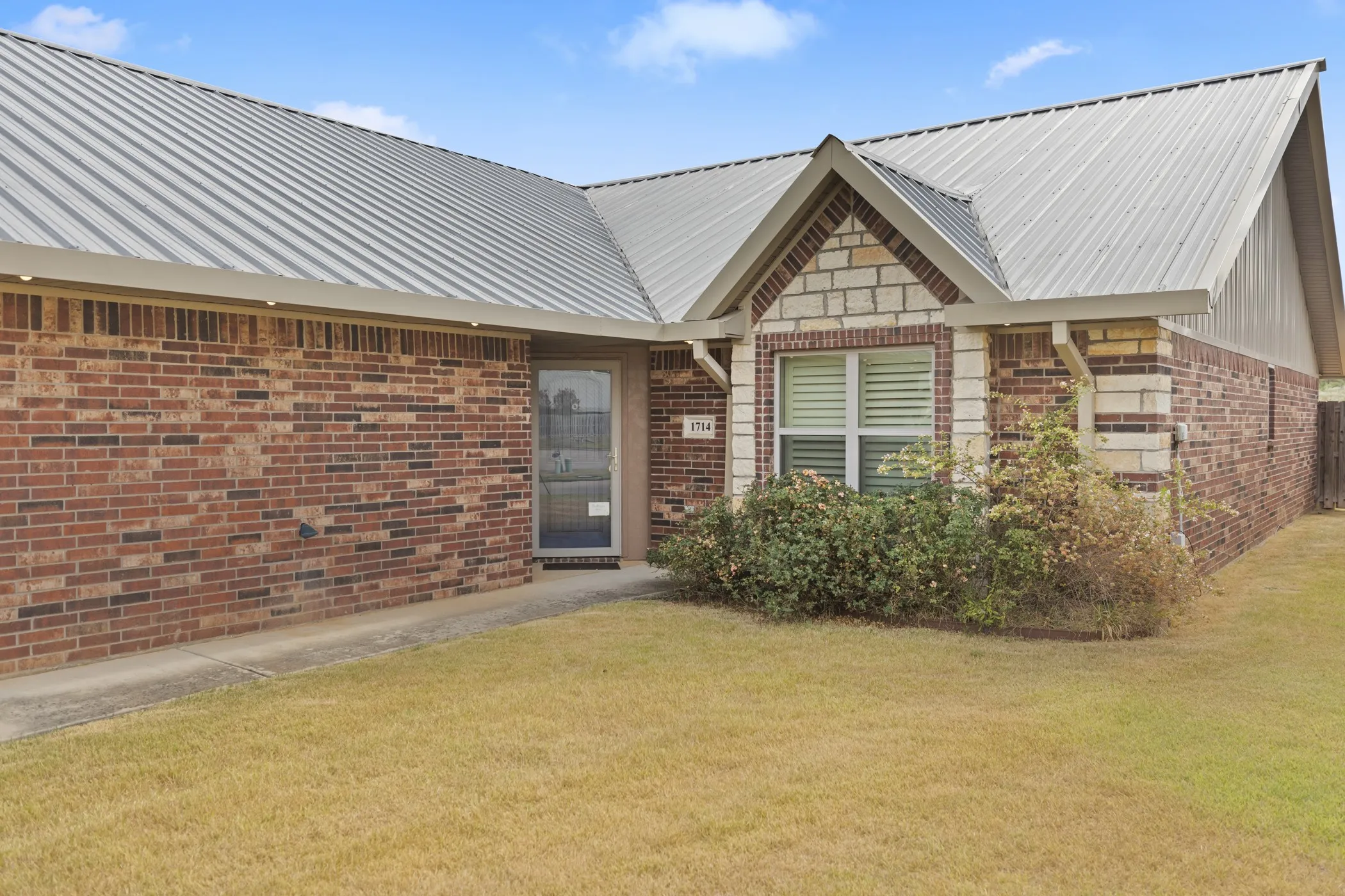 Brick and stone exterior with a metal roof